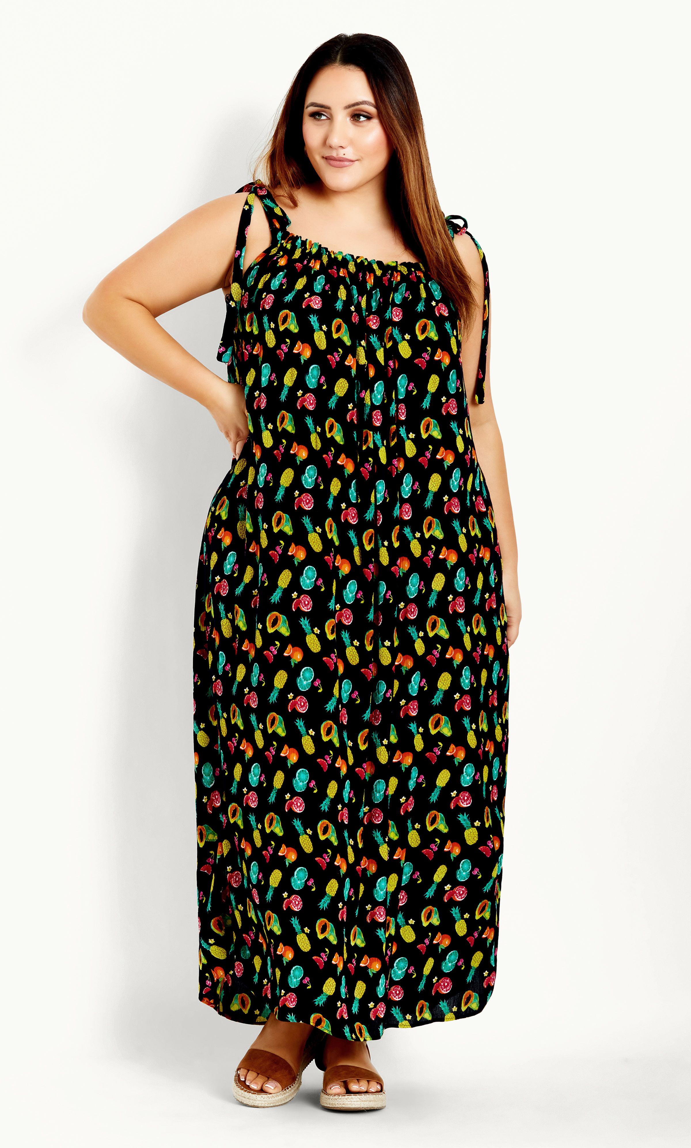 The Tie Shoulder Dress features a super cute fruit print and comfortable relaxed fit, perfect for soaking up the sunshine in style. Featuring tie shoulder straps for added feminine flair, this dress is a stylish pick for beachside strolls and picnic dates. Key Features Include: - Straight elasticated neckline - Self-tie shoulder straps - Textured non-stretch fabrication - Relaxed fit - Pull over style - Unlined - Maxi length Complete the look with strappy black sandals and an oversized straw hat.