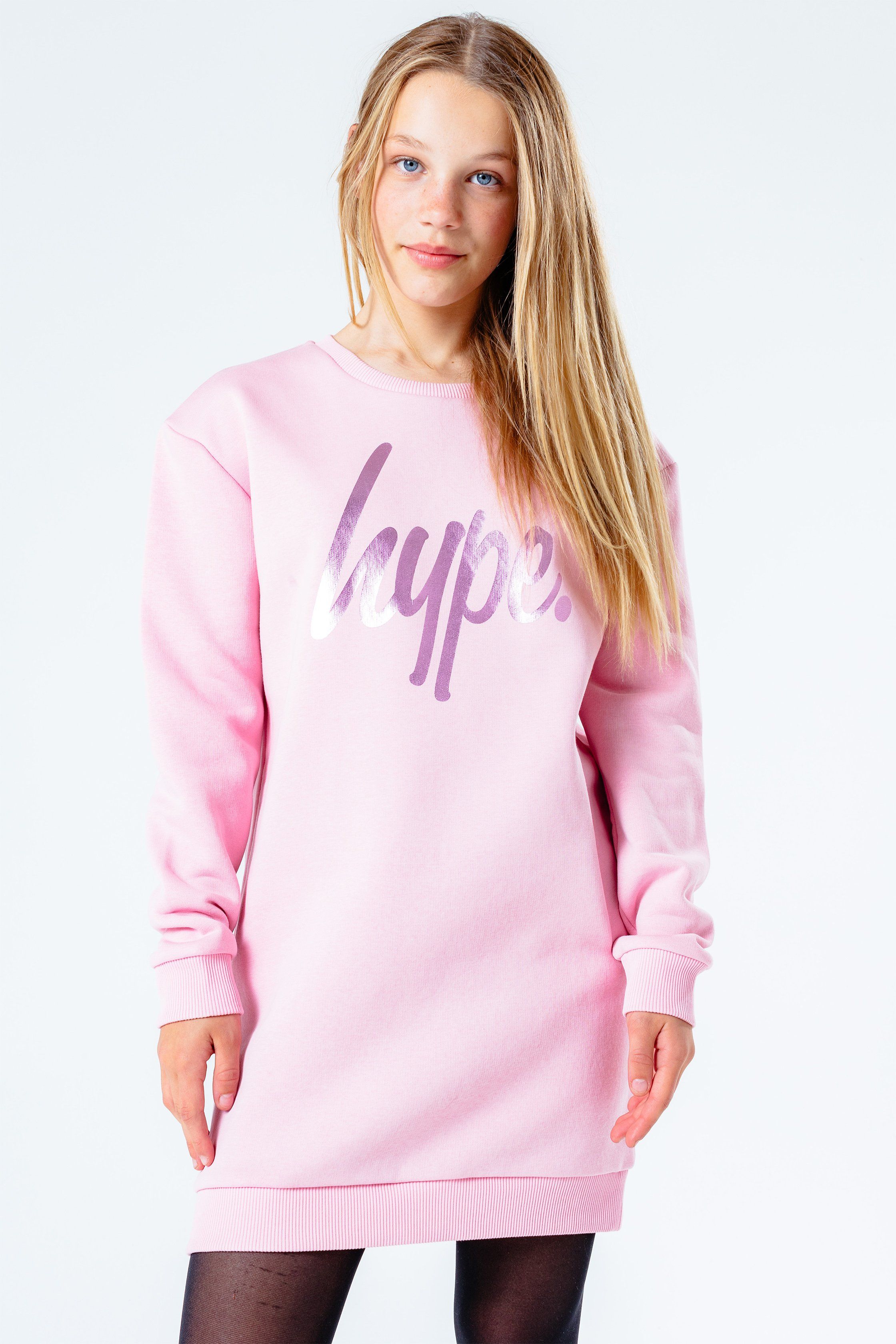 The cutest dress you'll need this season, and every season after that. The Hype. foil print girls sweat dress features our iconic HYPE. script logo in a holographic transfer. The fabric boasts a pink soft-touch base for supreme comfort. With a crew neckline and long-sleeves with fitted cuffs. Wear with cute sandals to complete the look. Machine wash at 30 degrees.
