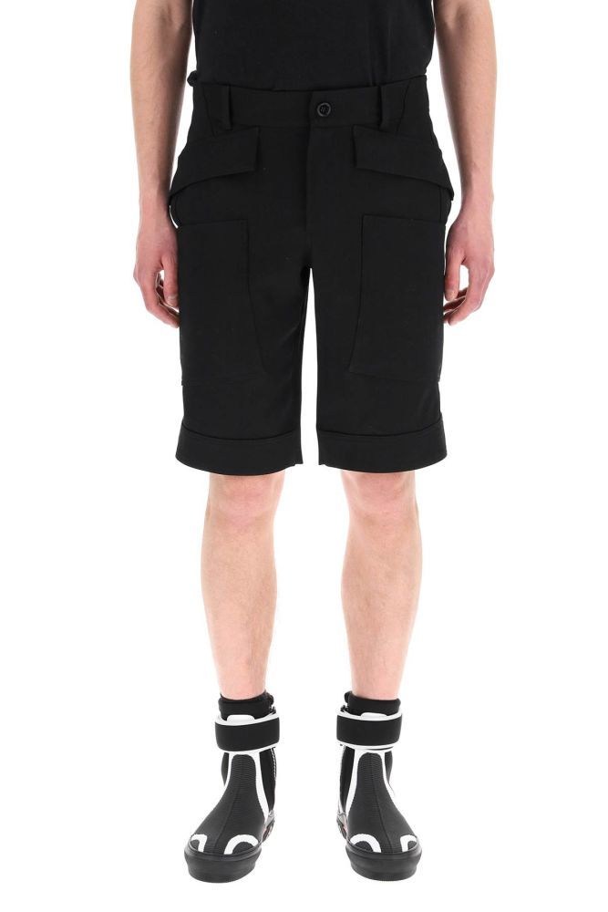 Knee-length cargo shorts by Burberry, cut from wool fabric to a comfort fit. They feature button tabs at the hem, regular waist with belt loops, zip fly and button closure. Front flap pockets, side inseam pockets, patch cargo pockets. Utility pockets and patch pockets on the back. The model is 187 cm tall and wears a size IT 48.