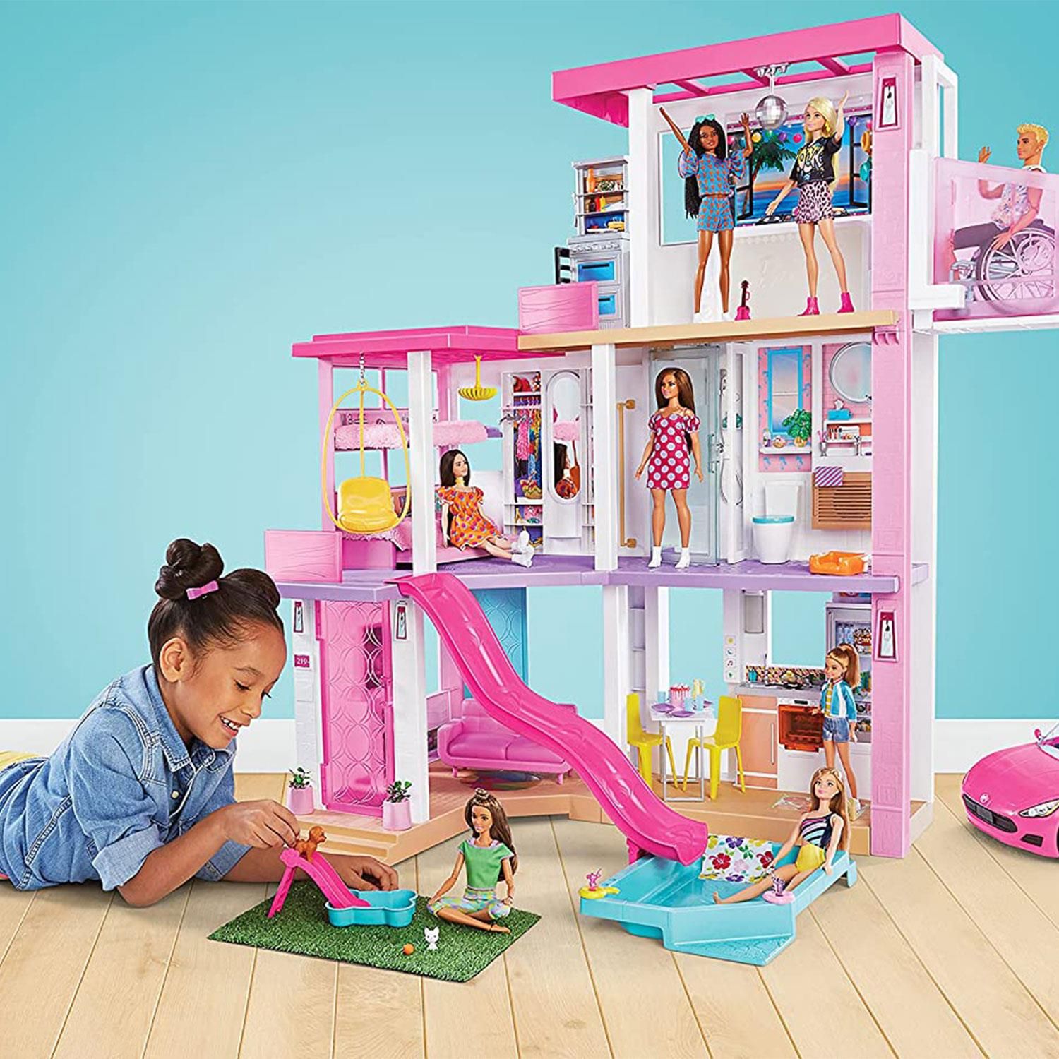 When young imaginations open the door to the Barbie Dreamhouse, they'll discover unlimited storytelling possibilities! Standing 43 inches tall and 41 inches wide, this dreamy dollhouse inspires 360-degree play with three floors and 10 indoor and outdoor living areas. Move right in and customize the space -- the grass area and pool can be placed in multiple configurations on the first and third floors, and the slide fits in four second-floor locations. After designing the layout, set the scene for any story with three songs, two soundscapes and customizable light settings! Then, double the fun with transforming furniture -- the BBQ grill reverses to reveal a dessert buffet, the entertainment centre reverses to reveal a pet play area, and a bunk bed folds down from the wall. Kids can play out any story, from an ordinary day to the ultimate get-together with a kitchen, living room, dining room, bedroom, bathroom, pool, balcony, party room and more. Lift and lower Barbie doll and her friends in the working elevator, fill the pool with water to make a splash, soak up some sun on the third-floor balcony and rooftop deck, and host a pet playdate with a puppy pool and slide. Storytelling accessories -- over 75 of them! -- feature realistic touches and textures that bring any Barbie story to life. With cool customizations and so many storytelling opportunities, kids ages 3 years old and up will move right into the Barbie Dreamhouse and make it their own! Assembly required. Dolls, vehicle and wheelchair not included. Requires 3 AA (LR6) alkaline batteries (not included). Colours and decorations may vary.