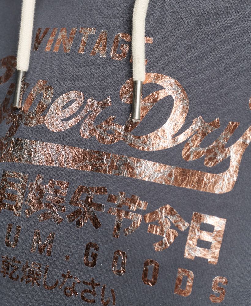 Our Vintage logo is part of our heritage and it's become iconic. Become part of that history with the Vintage Logo Tonal hoodie. The classic hoodie design that lives in so many wardrobes is paired with a crushed effect foil print logo that elevates this staple.Relaxed fit – the classic Superdry fit. Not too slim, not too loose, just right. Go for your normal sizeDrawcord hoodFront pouch pocketRibbed cuffs and hemSleeve logo patchFoil printed logoBrushed lining