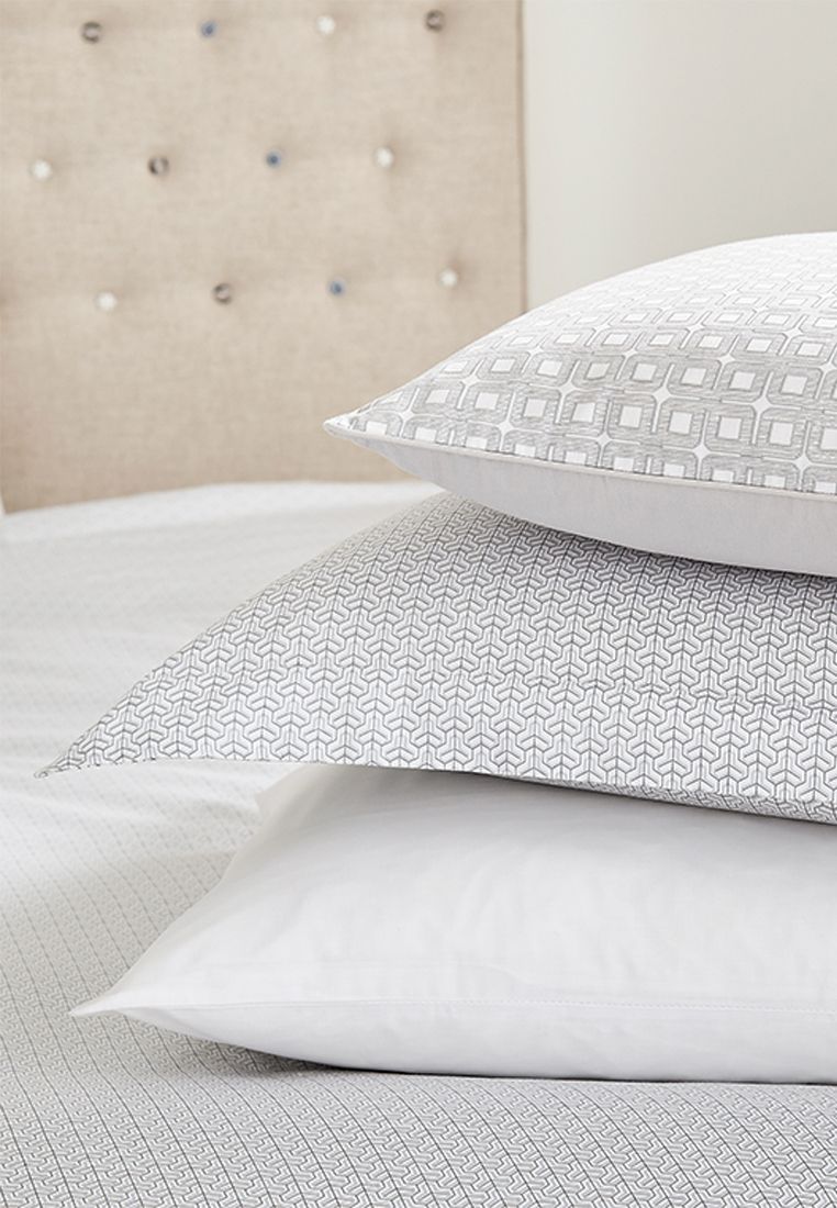 Nikko from Bedeck of Belfast Fine Linens displays a subtle yet sophisticated all over geometric tile print in silky 100% cotton sateen. Available in a choice of silver or linen. Enhance the look further with the coordinating Nikko cushion with repeat interlocking square design embossed with a textured finish and fine cord piping all in 100% cotton sateen also available in silver or linen. Made in Pakistan.