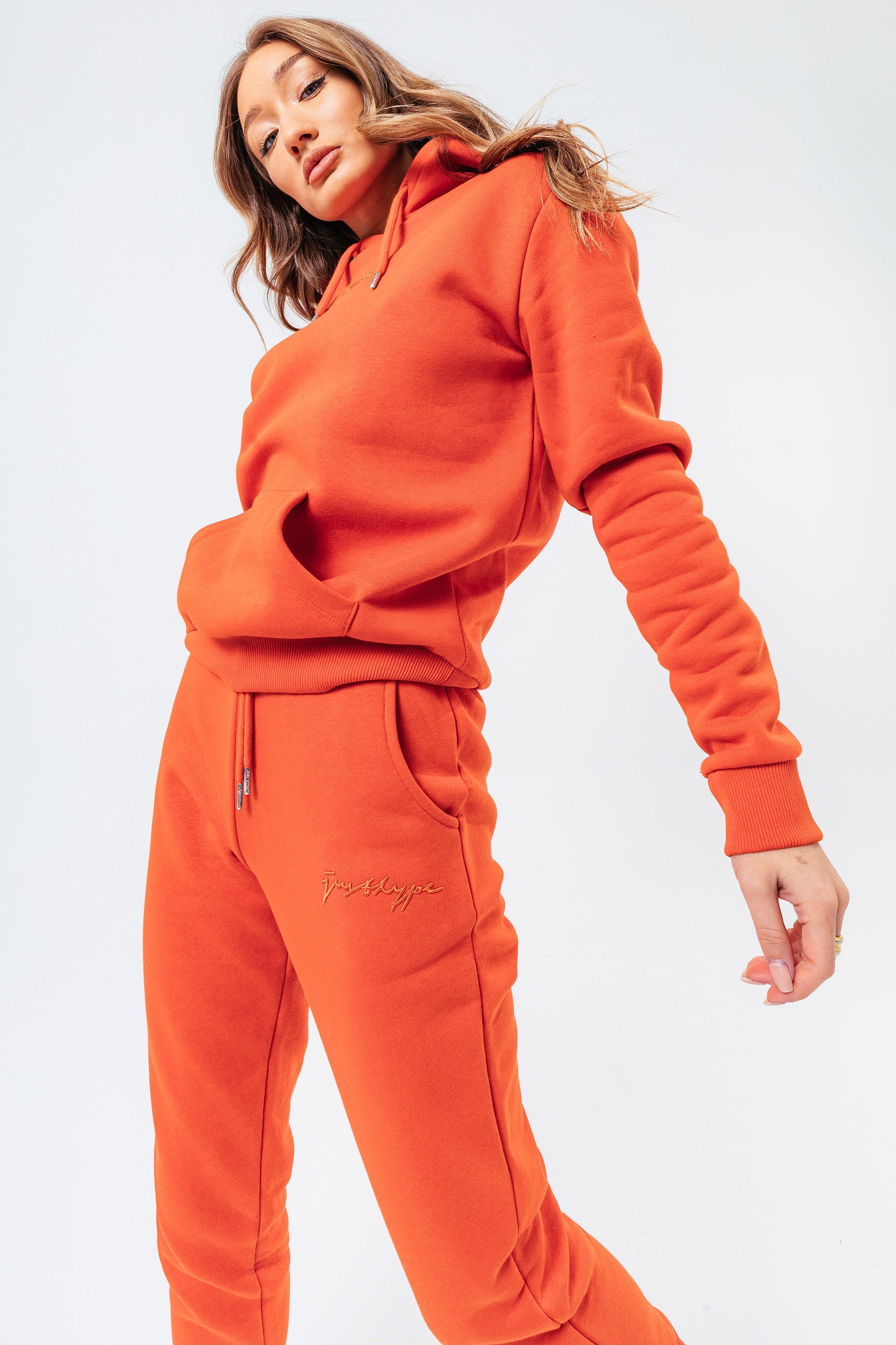Introducing the freshest loungewear set you've ever seen! The hype dark orange with tonal signature script women's hoodie & jogger set is your new go-to loungewear set when you need that extra comfort boost. Designed in 80% cotton 20% polyester for the ultimate soft touch feeling! The hoodie features a fixed hood, kangaroo pocket, fitted hem and cuffs, finished with drawstring pullers and embossed justhype embroidery across the front in the same colour. The joggers highlight an elasticated waistband, fitted cuffs and double pockets with tonal drawstring pullers and embossed justhype embroidery on the side of the leg. Wear together or stand alone with a pair of box fresh kicks. Machine washable.�