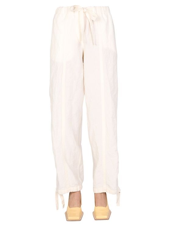 Loose fit trousers in linen and cotton fabric by Jil Sander, detailed with drawstring waist and cuffs. Button fly, centre leg seams, side inseam pockets, a patch pocket on the back. The model is 177 cm tall and wears a size DE 34.