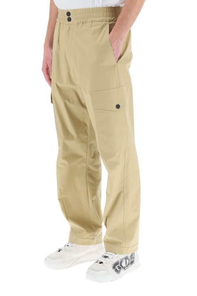 MSGM cargo pants in lightweight stretch cotton gabardine, featuring a straight cut with ergonomic curvature at the knees. Side slash pockets, two cargo pockets, a rear patch pocket with studded flap. Elasticated waist, closure with zip fly and two snaps. Flag logo label sewn on the back pocket. The model is 187 cm tall and wears a size IT 48.