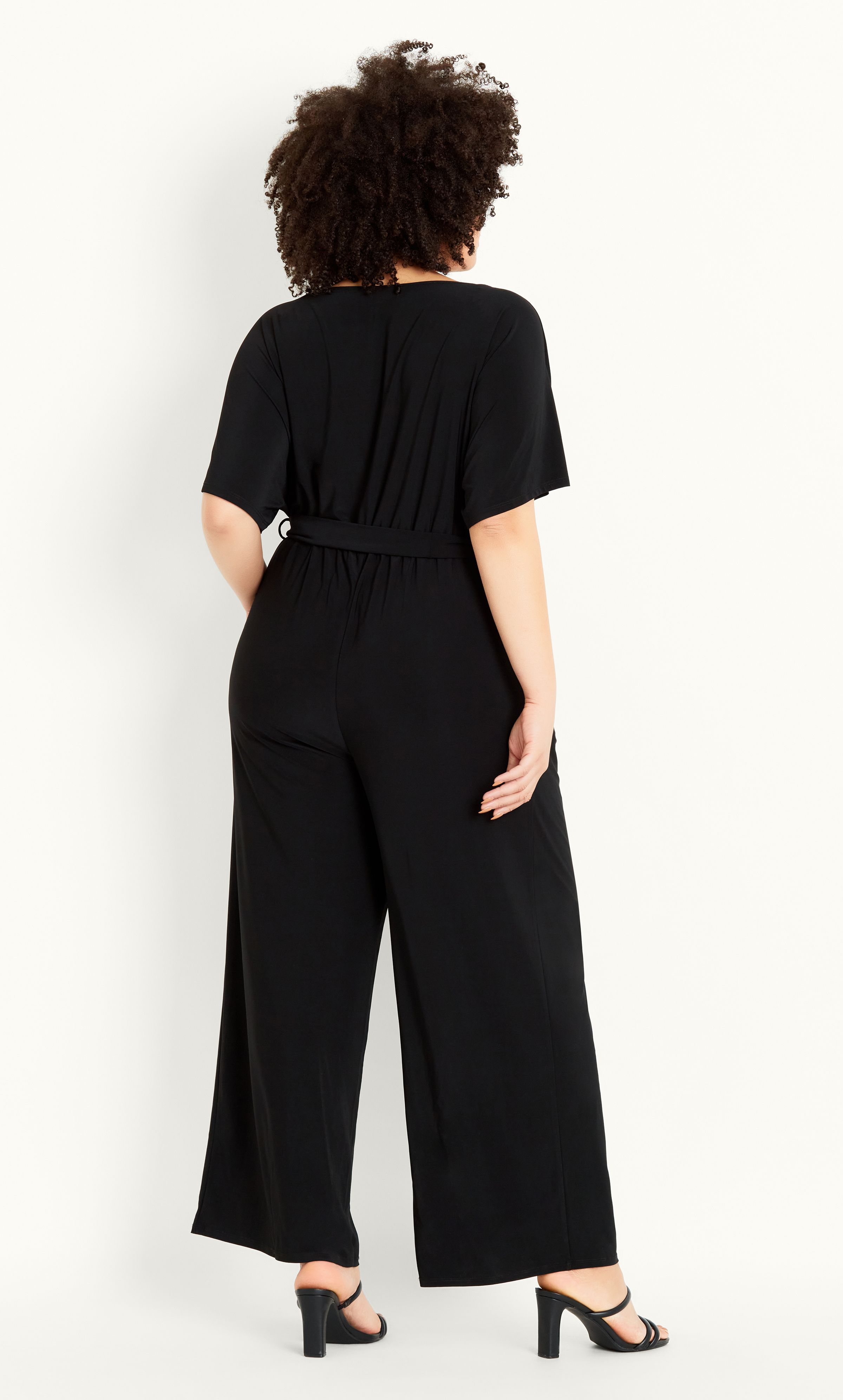 Sleek, chic and all kinds of curve-loving, the Wrap Tie Belt Jumpsuit is as flattering as it is utterly on-trend! Flirting with a plunging V-neck line and cinched waist, as well as a fashionable wide leg, this jumpsuit is a go-to when it comes to classy cocktails and after work drinks. Key Features Include: - Faux wrap V-neckline - Short sleeves - Side pockets - Elasticated waistline - Removable self-tie waist belt - Soft stretch fabrication - Relaxed leg - Unlined - Pull up style - Full length Add a touch of opulence with statement earrings, strappy stilettos and a fierce red lip.