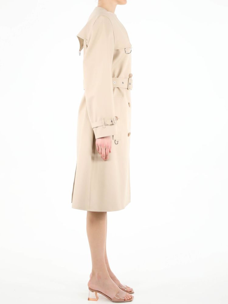 Beige cotton raincoat with double-breasted closure. It features front buttons, adjustable belt on waist, two side buttoned welt pockets, adjustable buckle on cuffs and back slit. The model is 178cm tall and wears size 8.