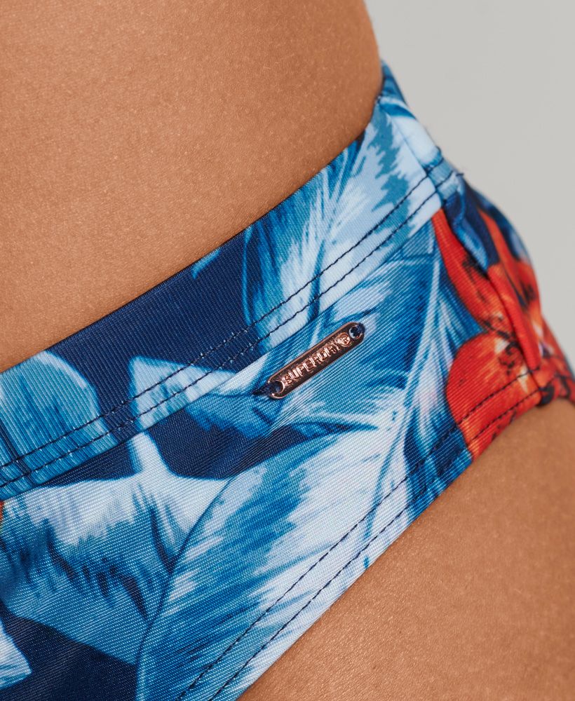 Hawaiian print is an iconic part of the classic vintage vibe, and we love how it evokes a retro style. Whether you're travelling far or staying at your local spots this sunny season, you can bring the holiday spirit with you anywhere you go. These briefs have a bold chic, whether worn by themselves or beneath a day dress on those lovely long days.Hipster brief styleAll over printElasticated waistMetal Superdry tabRecycled contentsPlease note, due to hygiene reasons we are unable to offer an exchange or refund on swimwear unless the hygiene strip is still intact. This does not affect your statutory rights.By 2050, there will be more plastic in the ocean than fish.Help save plastic from polluting the earth. Wear this instead.This new swimwear fabric is made from 80% recycled post-consumer waste.