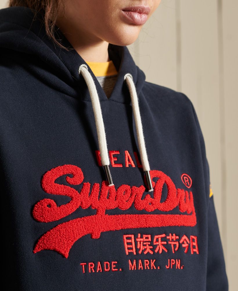 Inspired by Americana style, our Vintage Logo Chenille Hoodie will bring you those authentic vibes you need to mix up your wardrobe.Relaxed fit – the classic Superdry fit. Not too slim, not too loose, just right. Go for your normal size.Drawstring hoodChenille LogoEmbroidered letteringLarge front pocketRibbed cuffs and hemBrushed liningSignature Superdry logo patch