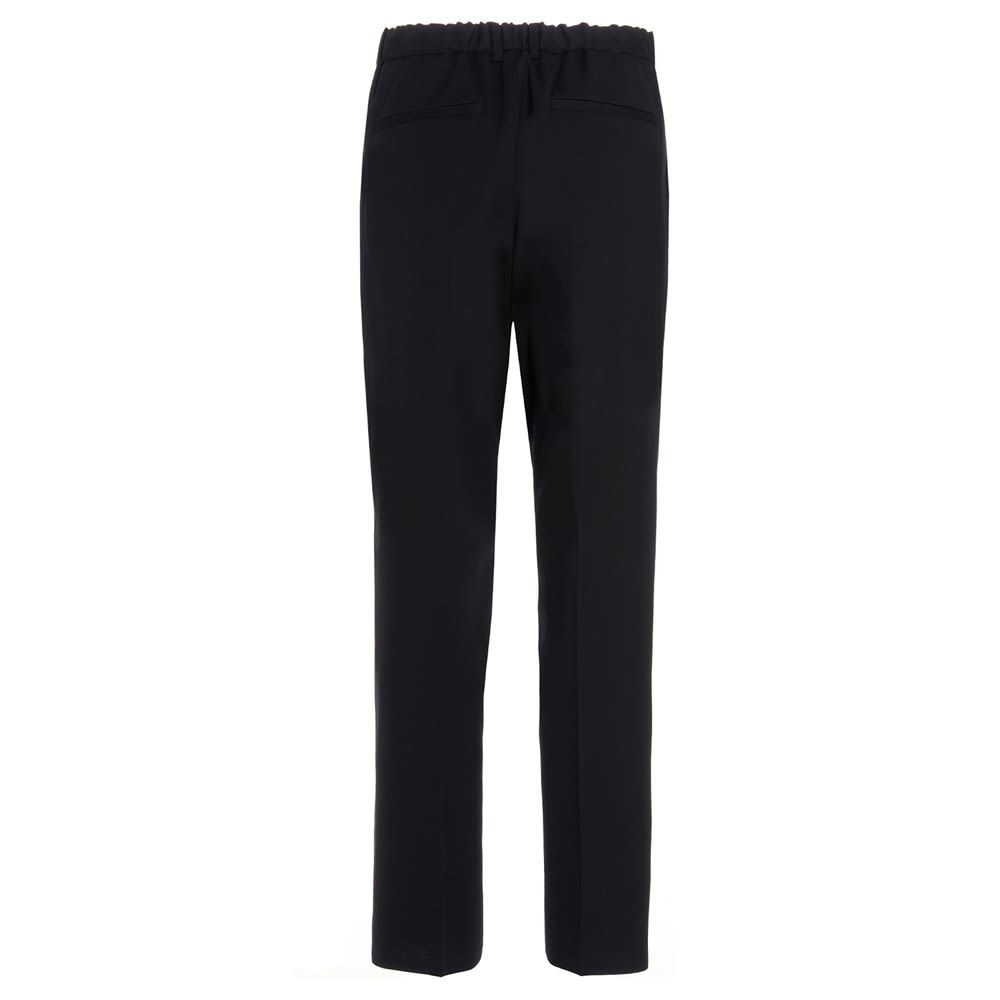 Very dark blue wool trousers with a central pleat, a zip, hook-and-eye and button fastening, welt pockets, a tapered cropped leg, and a relaxed fit.