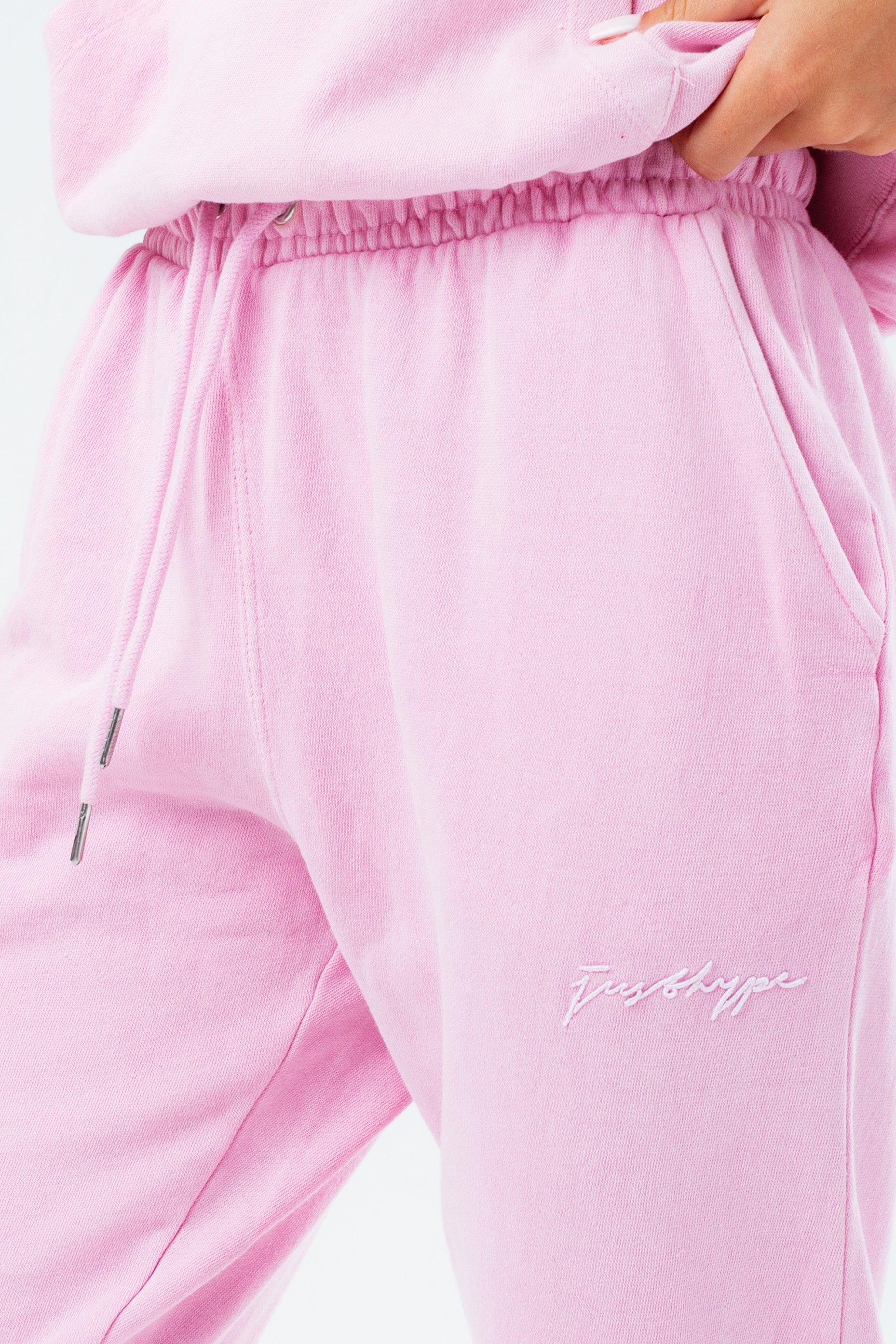 Stay on trend with the Hype Washed Baby Pink Scribble Logo Women's Joggers and grab the matching hoodie to complete the set. Designed in a soft-touch 70% Cotton 30% Polyester fabric base with the supreme amount of comfort you need from your new joggers. The design boasts an acid wash or tie-dye wash finish with an elasticated waistband, drawstring pullers and fitted cuffs. Machine wash at 30 degrees.