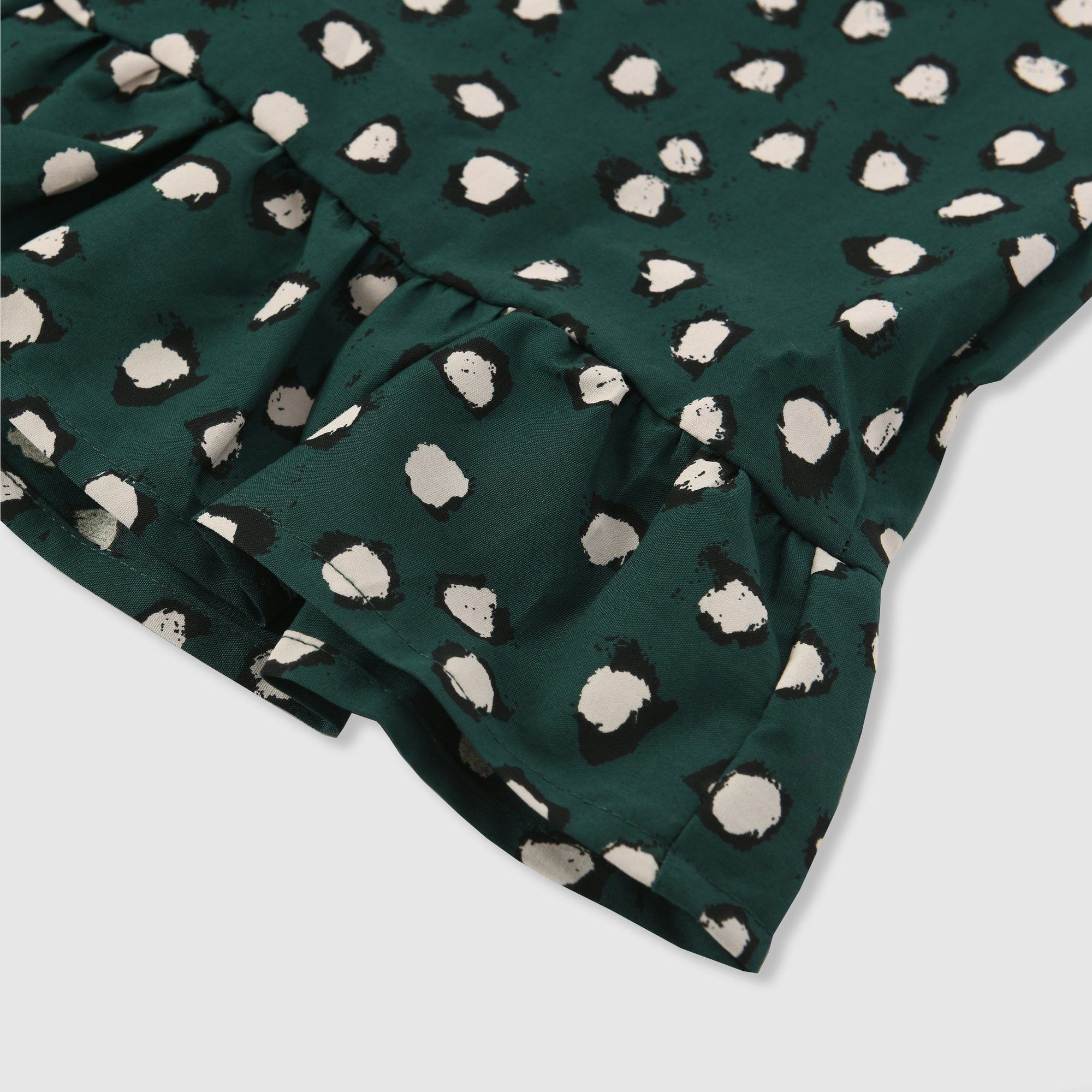 Simple lightweight 100% cotton pinafore dress in our bespoke painted dot print in green with black and white dots. Features a single button adjustable back closure and ruffle hem. 