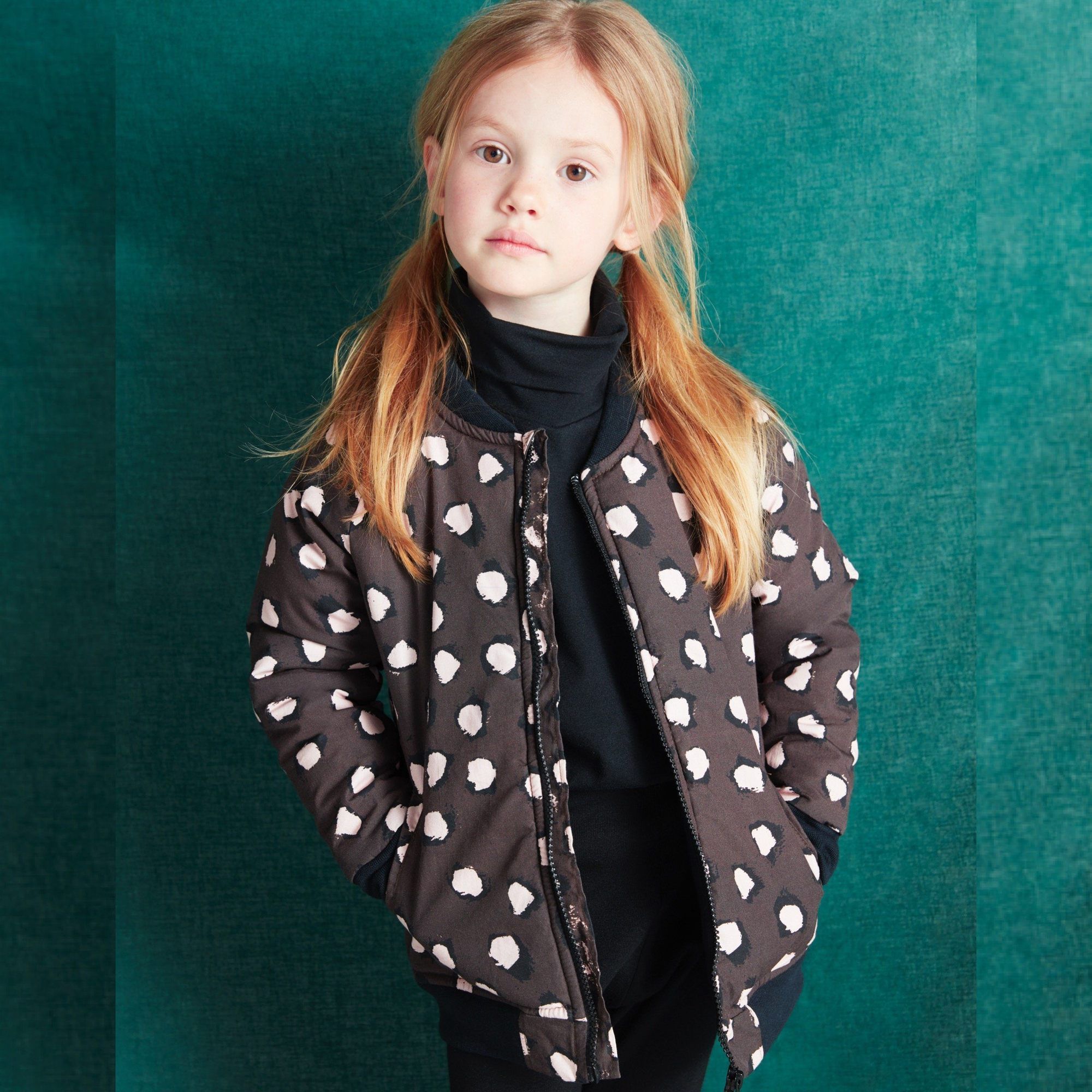 Lightweight cotton bomber jacket in brown featuring our all over painted dot print in pink and black. Inside lining and ribbed collar in matching black jersey to give our little ones extra warmth and comfort. Features zip opening front for ease of dressing and front pockets. Designed to be unisex.