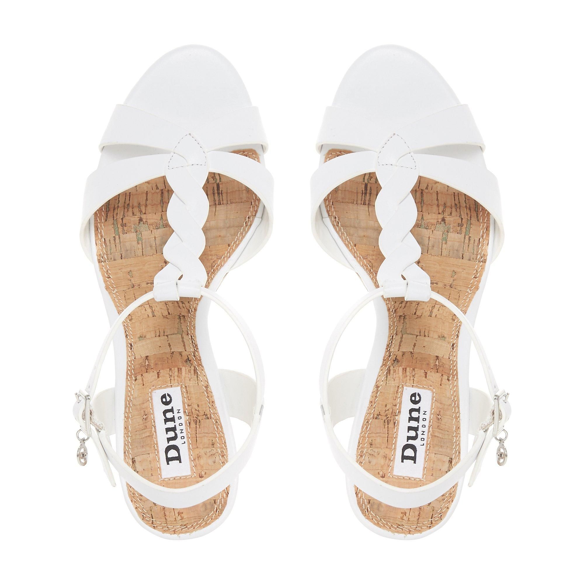 Perfect your summer day-to-night edits with the stylish Koala heel. Featuring a plaited T-bar strap with an open back and a buckle fastening. A sandal toe and a cork effect mid-wedge heel complete the design.