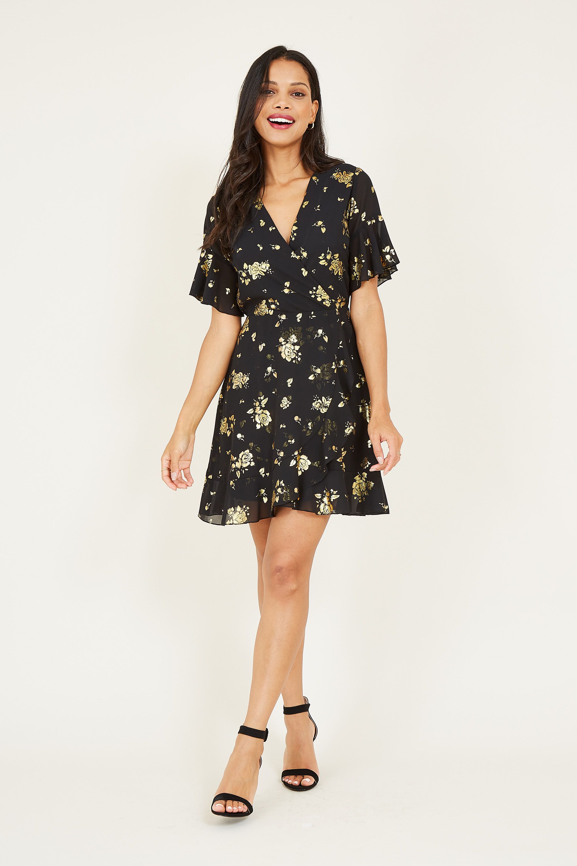 Printed with pretty foil florals running from the shoulder to the hemline, this Mela Foil Floral Skater Dress is a wardrobe hit. Featuring lightweight fabric that ties at the waist, it's styled with short floaty sleeves and gentle ruffles. A lining runs undernetah to aid movement, accessorize with anything from trainers to heels.