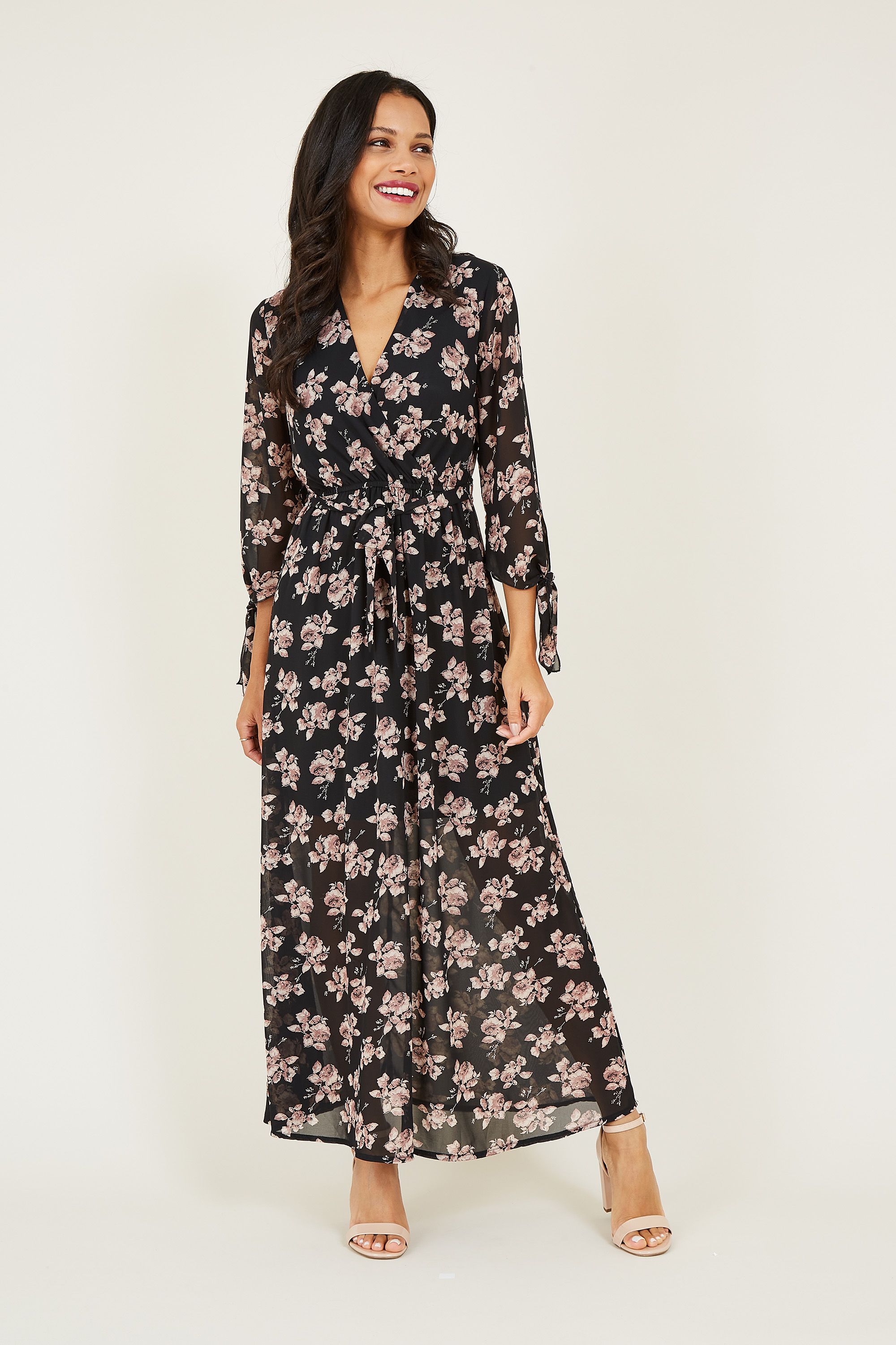 For effortless dressing with a feminine feel, opt for this Mela Rose Maxi Dress. Falling to the ankle, it's designed with long sleeves enhanced by sweet ties and a V-neckline. Secured by a waist tie, the lightweight fabric is printed with pretty florals to enhance your eveningwear. Accessorize with heels for an elegant finish.
