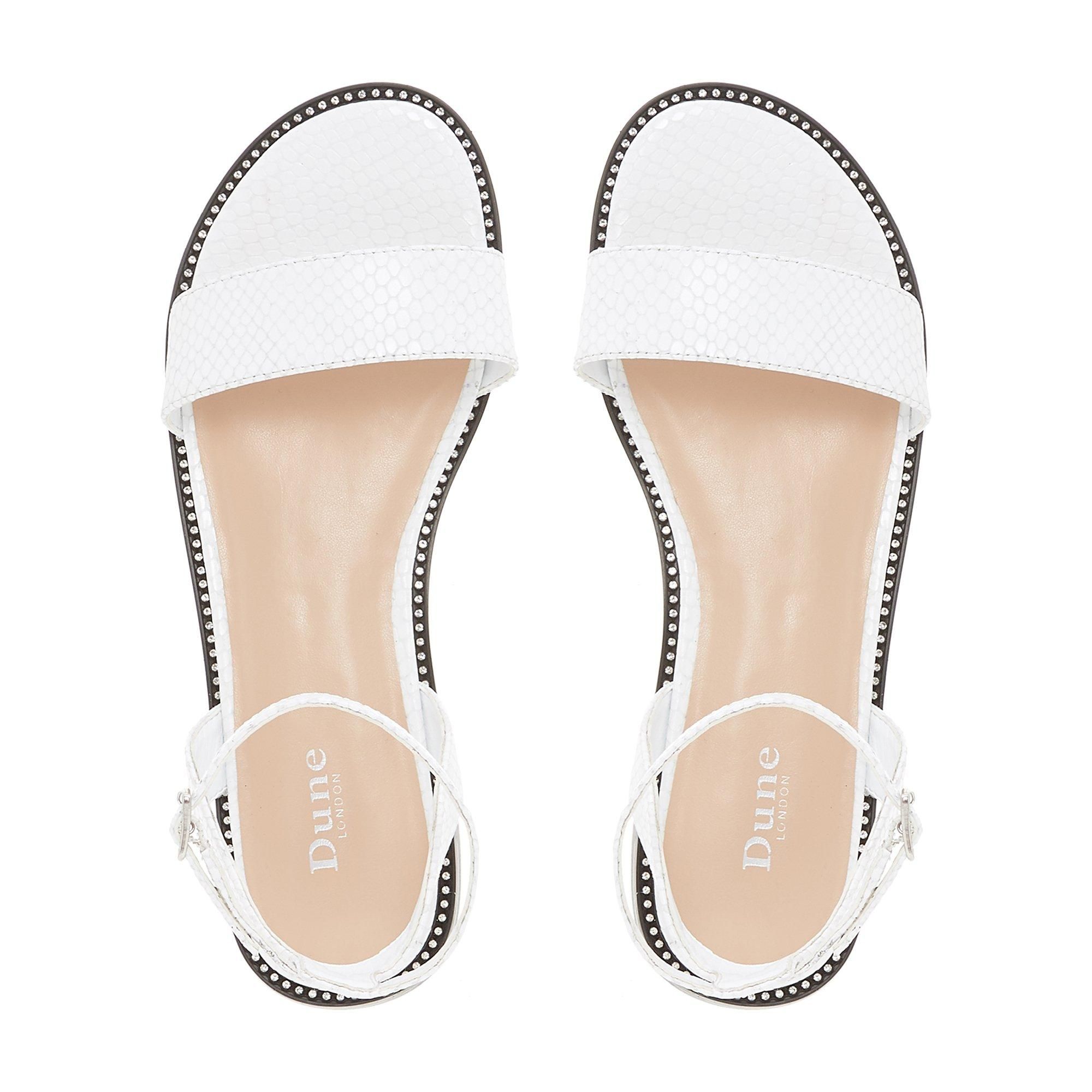 The Dune London Nance two part sandal is a chic summertime style. Featuring a textured slim front strap, an open back and ankle strap. It's perched on a low block heel with an understated studded trim.