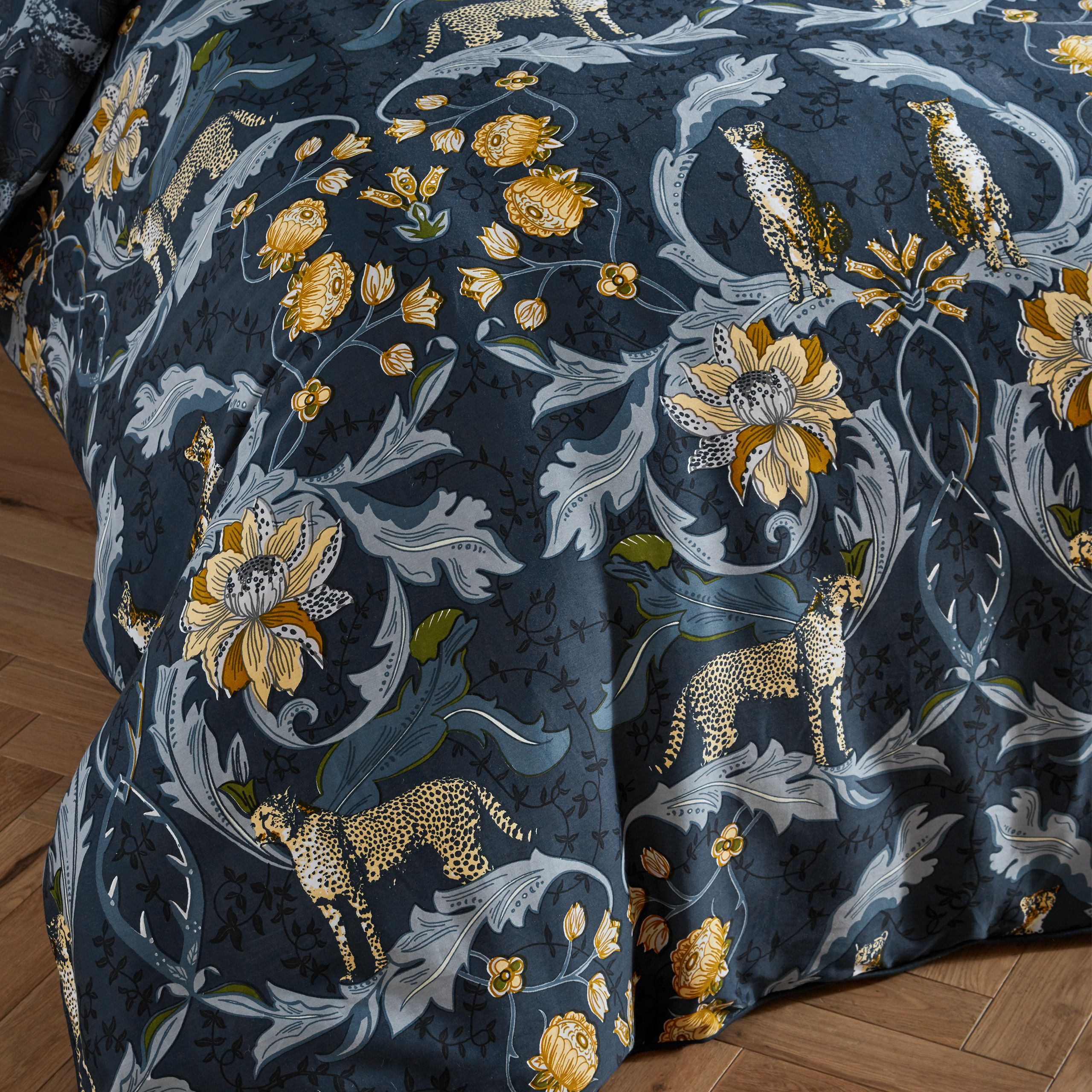 Inspired by Art Nouveau botanical illustrations, Nouvilla is a highly decorative design featuring charming cheetahs amongst meandering curves of plants and flowers. This luxury cotton sateen bedding features contrast piping, oxford edge pillowcases and a tonal coordinating print on the duvet cover reverse. This duvet cover set has been produced to a meticulous standard, with a thread count of 200 threads per square inch, to ensure a soft, smooth and long-lasting fabric.