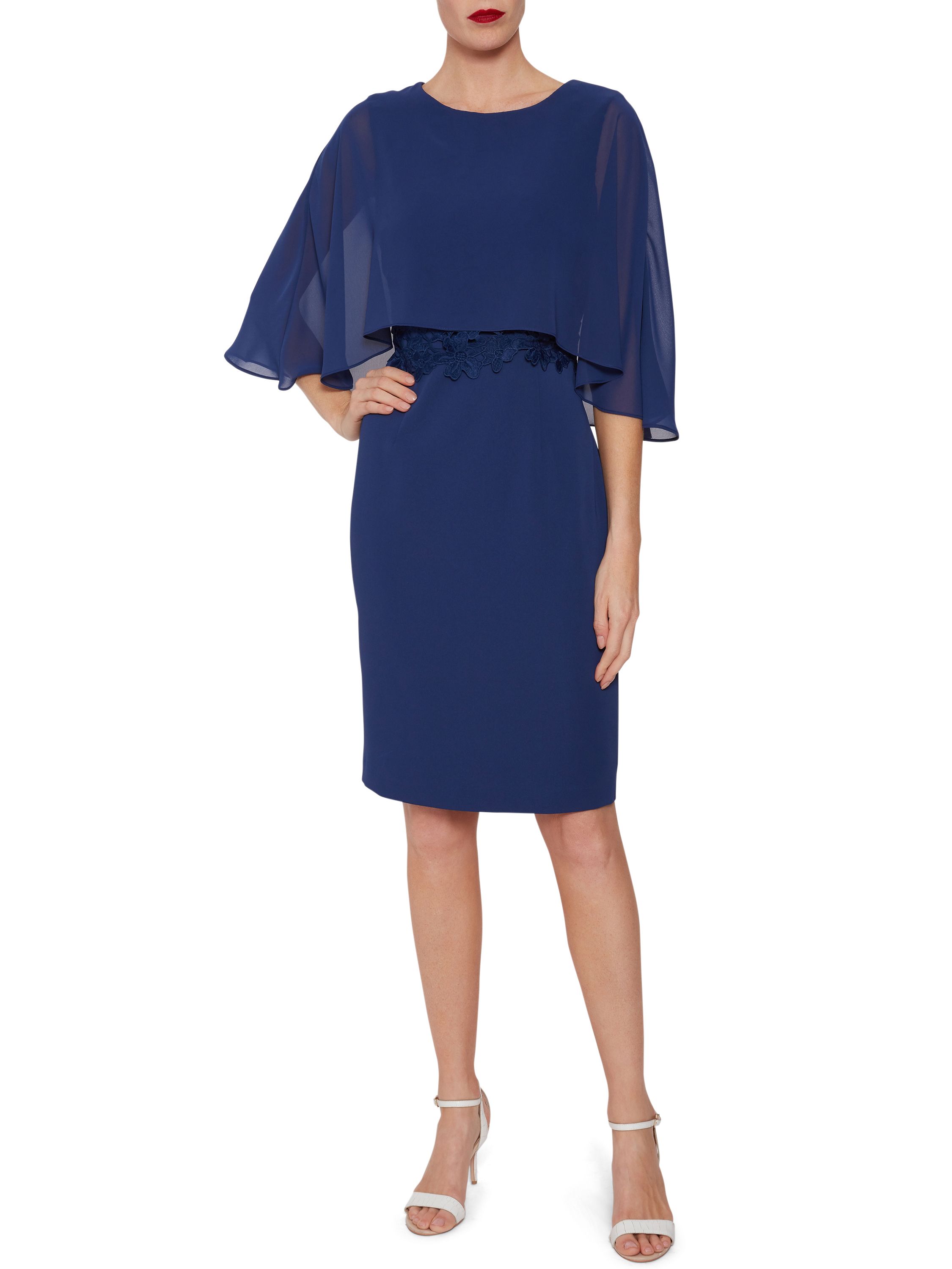 Make this stylish crepe dress and cape by Gina Bacconi one of your staple items this season. Fashioned from a gorgeous soft crepe fabric, the dress takes a simple shift shape to flatter the figure, accompanied by a cape attached at the neckline to cover the shoulders, featuring a guipure lace bodice underneath the cape for extra detailing. Fastened with a concealed side zip.