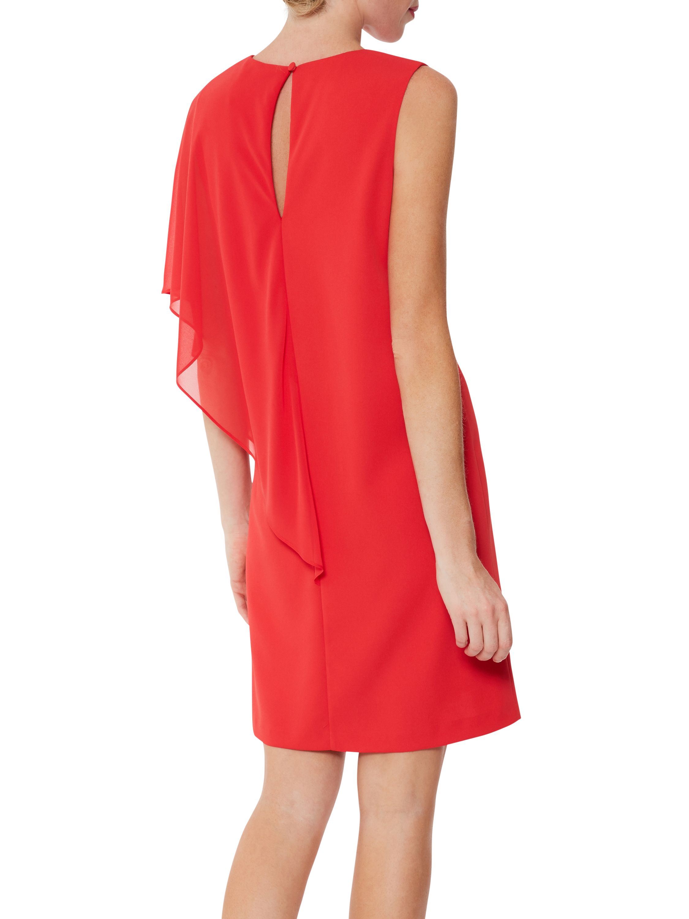 Add this Gina Bacconi chiffon dress to your party wear wardrobe this season. A simple yet classic shift dress has attached asymmetric cape that falls beautifully over the bodice to create an elegant silhouette. Perfect for a party or special ocasion. Fully lined, this dress fastens using a concealed back zip.