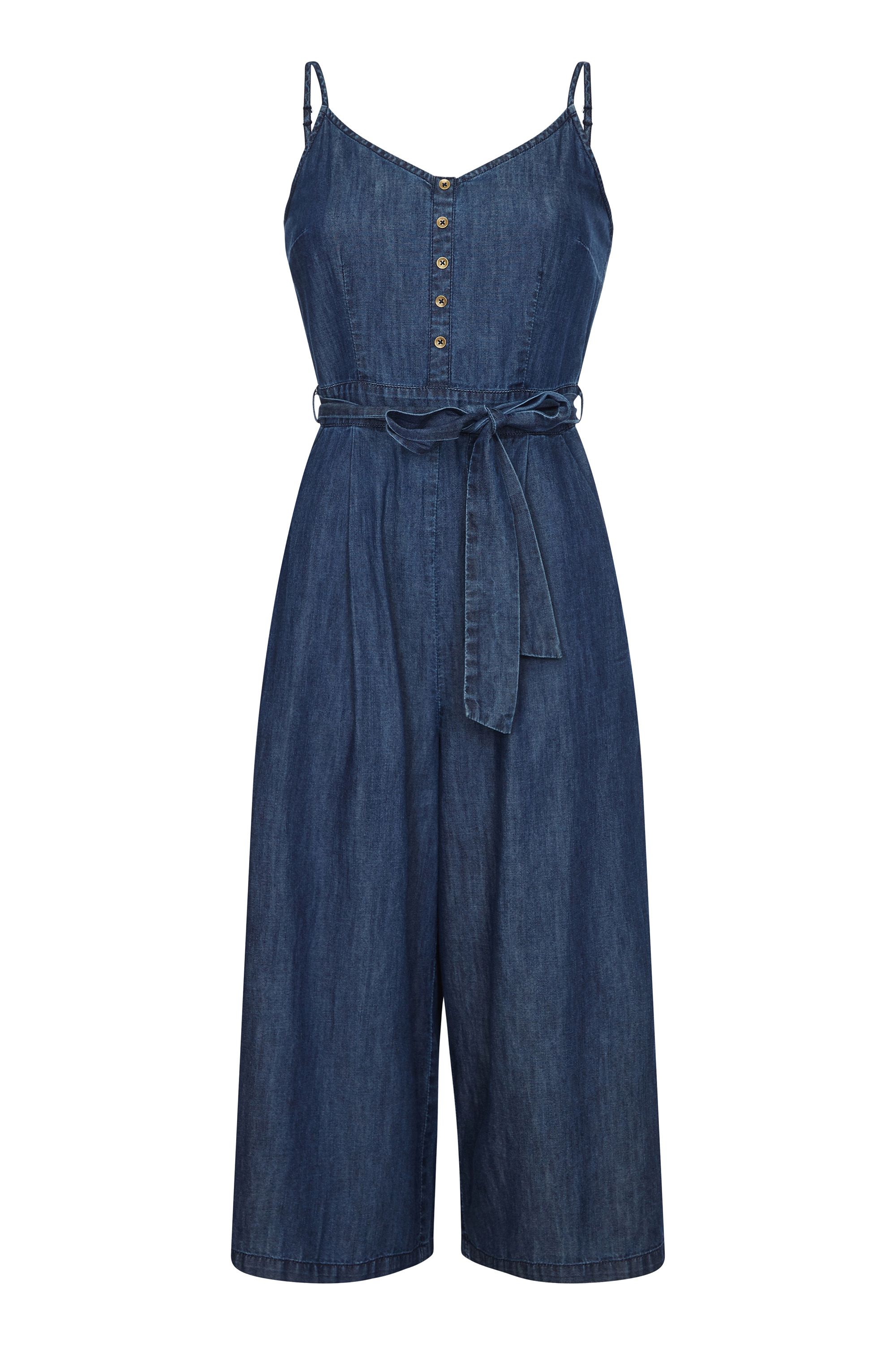 Do denim differently this season and opt for this Denim Jumpsuit With Button Detail. Falling on the knee, this casual jumpsuit features a sleeveless design and button detailing. The self-tie waist cinches your shape, while soft denim material is comfortable and figure flattering. Be bold this summer, partner this jumpsuit with statement heels and matching jewellery. 100% Cotton. Machine Wash At 30. Length is 110cm/43inches. Lilly is 5ft 9in, 180cm and wears size 10.