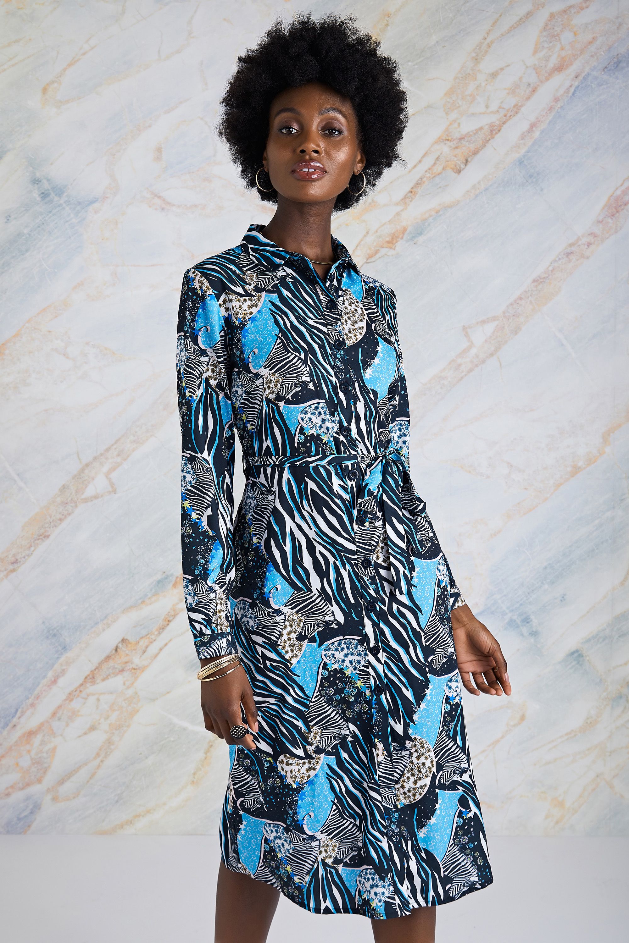 Where's Zack, the Yumi Zebra? Find him in our Hidden Zebra Print Shirt Dress! Super relaxed and sophisticated, this casual shirt dress features a standout zebra and ditsy floral print interspersed with bold colours. Designed in-house, it takes inspiration from 90s film sets and displays a relaxed shape enhanced by a curve-loving waist tie. The long sleeves allow you to wear it when the weather turns, while the silky-soft weave is perfect for keeping comfy.</span>100% Polyester</span>. Machine wash at 30</span>. 116cm/45inches</span>