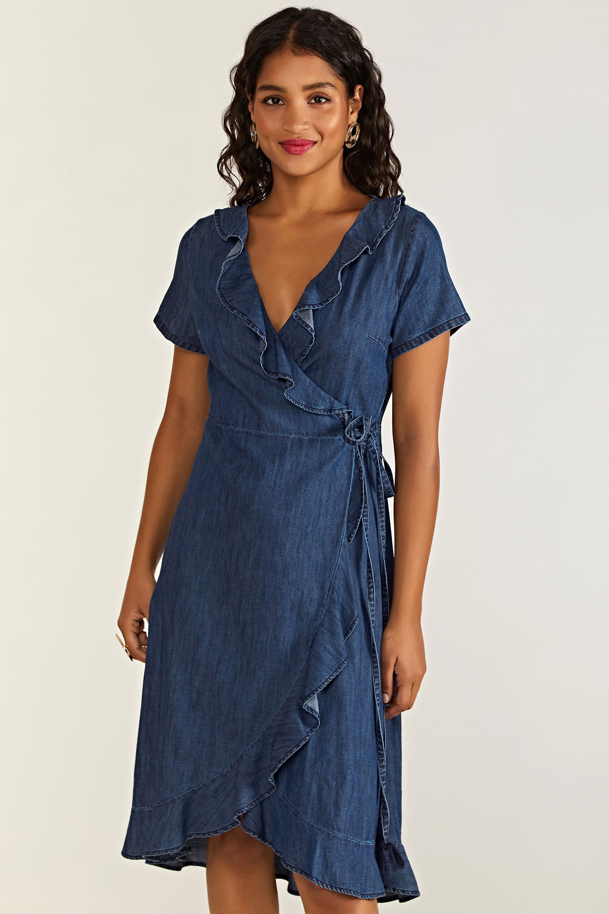 A staple of every wardrobe, this Denim Wrap Dress gives you an effortless choice between smart and casual. Cut in an elegant wrap shape that's super stylish, it's been enhanced with dainty ruffles and a self-tie waist. The cotton chambray gives it a lightweight feel, with a little stretch woven into the fabric for extra movement. Consider trainers and a rucksack for weekend adventures.100% Cotton. Machine Wash At 30. Length is 112cm/40inches
