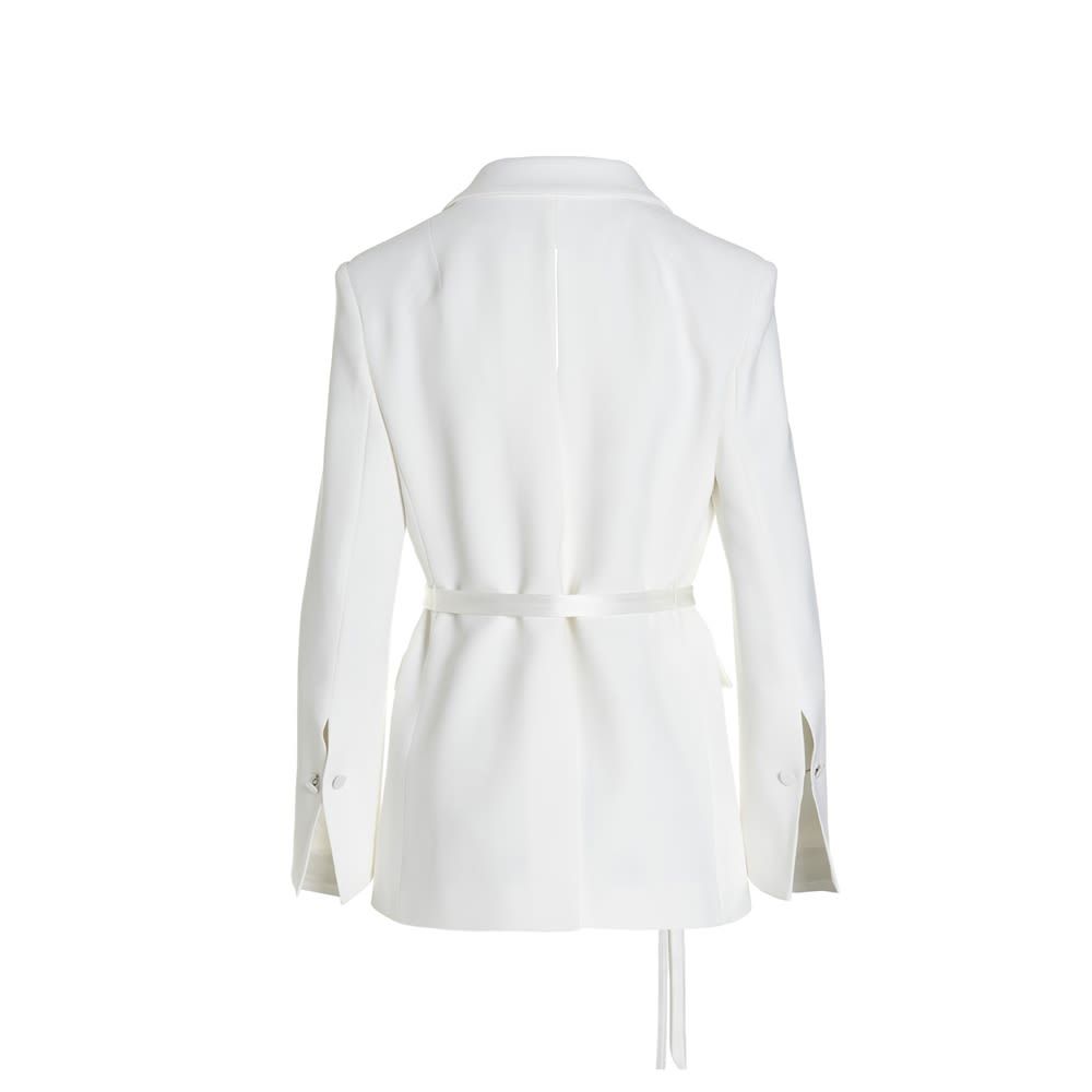 Single-breasted blazer jacket with cut-out detail, long sleeves, padded shoulders and woven belt at the waist.