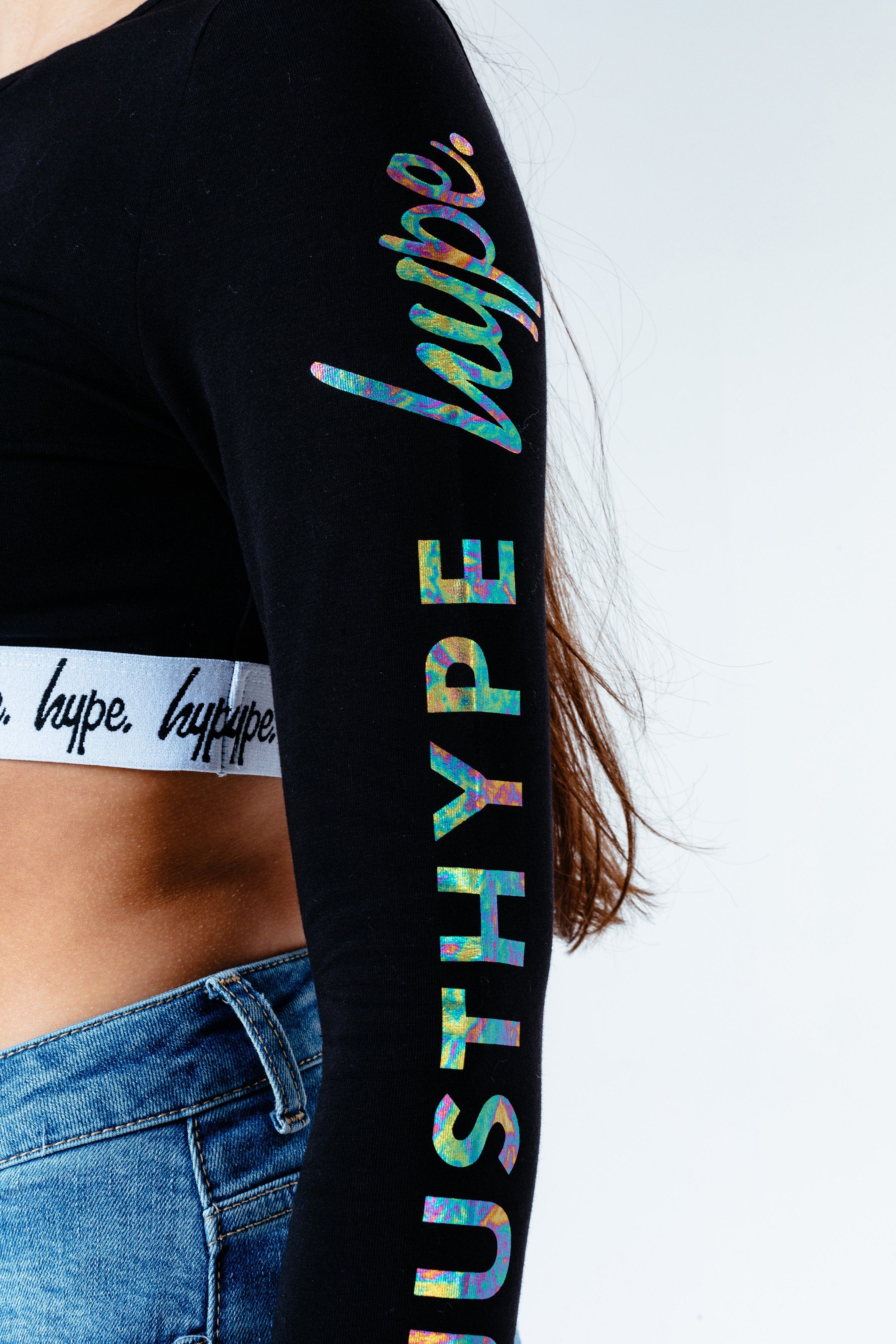 The HYPE. Foil Print Kids Crop Long Sleeve T-Shirt is the perfect workout tee. The top you wanna be wearing for your next dance class. Designed in an 92% Cotton and 8% Elastane fabric base for the perfect stretch and breathing room. With an embossed monochrome waistband, long sleeves and crew neckline. Finished with the iconic HYPE. script logo in holographic foil down the sleeves. Wear with HYPE. black legging and an over-sized shacket to complete the look. Machine washable.