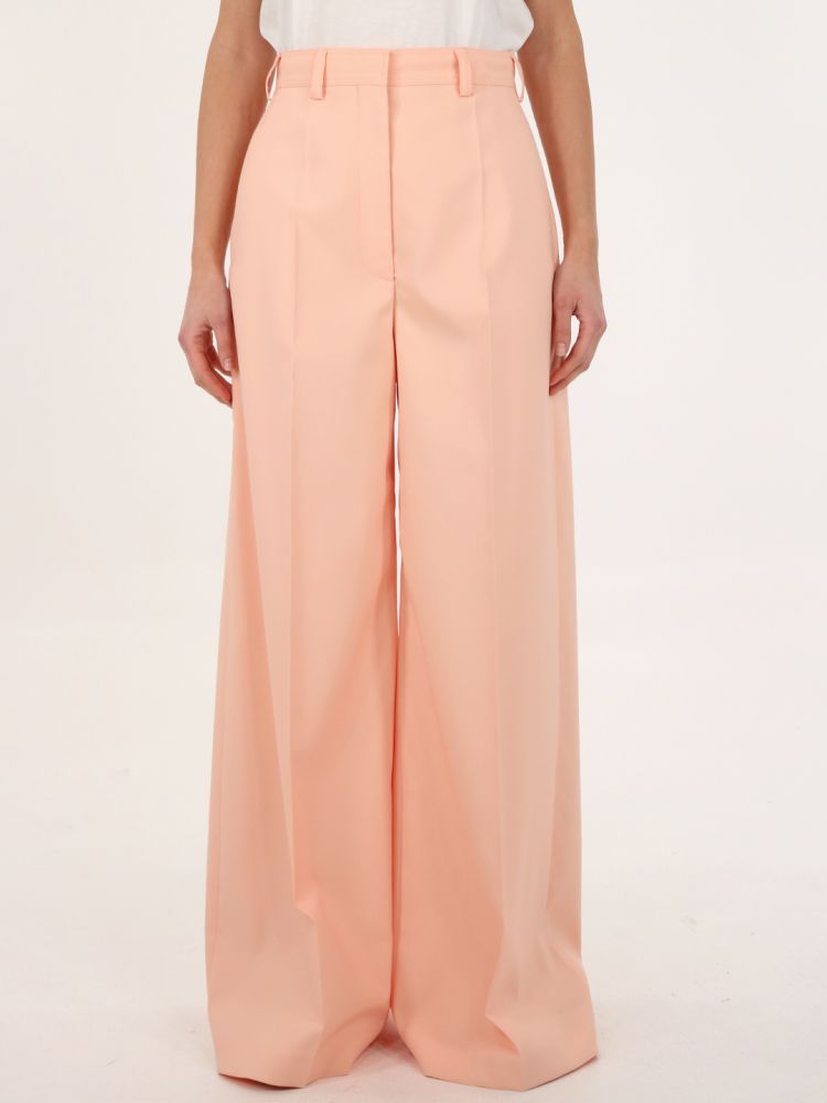 Wide-leg pants crafted in pink gabardine. They feature front button/hook/zip closure, side slanted pockets and belt loops. The model is 178cm tall and wears size 40.