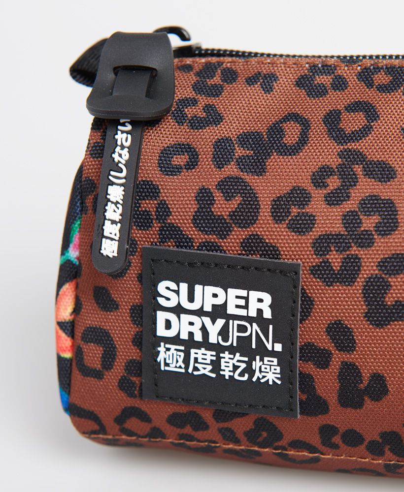 Superdry women's City Pack printed pencil case. Ideal for storing all your essential stationary. This pencil case features a print design with a spacious main compartment. This is finished with a Superdry badge on the front and Superdry branded zip tab.H 12cm L 23cm D 7cm