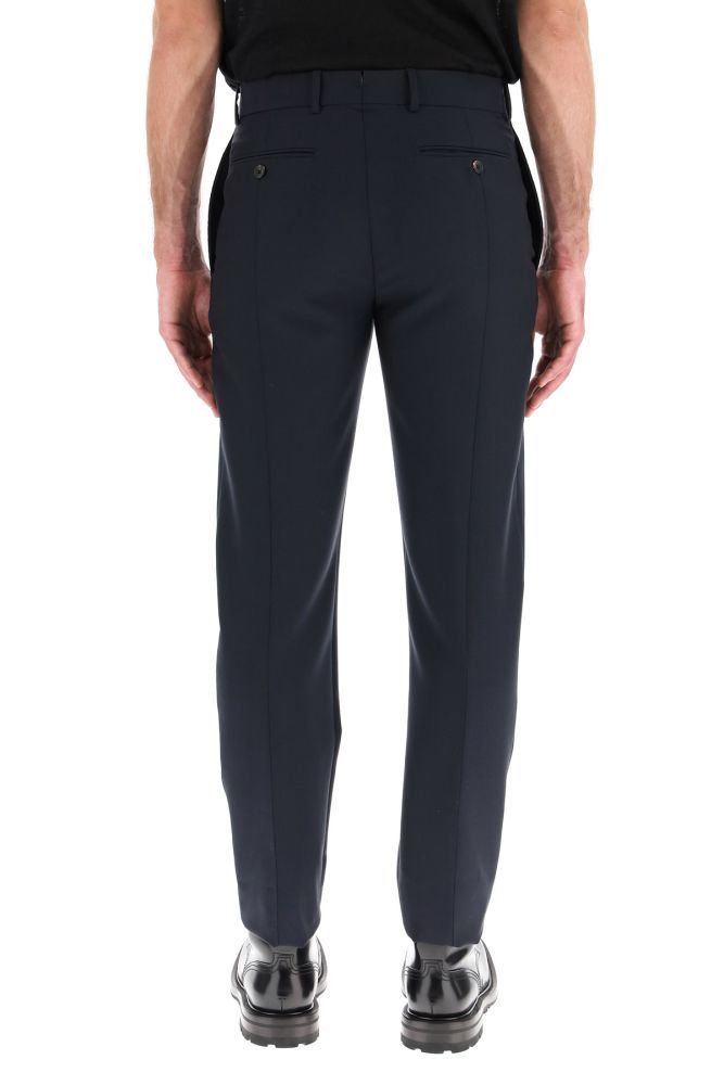 Alexander McQueen tailored trousers in lightweight wool and mohair fabric featuring a cigaret cut with ironed crease. They feature concealed zip and hook closure, side slit pockets, jetted back pockets with button, belt loops, back vent. They come unhemmed to allow further tailoring. The model is 183 cm tall and wears a size IT 46.