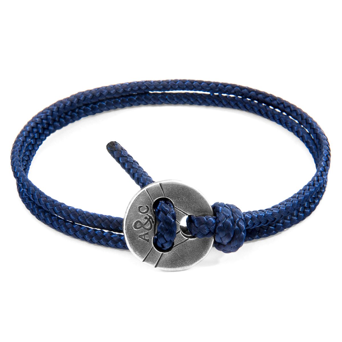 The Navy Blue Lerwick Silver and Rope Bracelet was both designed and skilfully handcrafted completely in Great Britain, In Quality We Trust. For the Modern Journeyman (and woman), ANCHOR & CREW takes ownership of an exploratory lifestyle and enjoys the Happy-Good Life. Combining British craft manufacturing with a discerning modern-minimalist style, this ANCHOR & CREW bracelet features:

3mm diameter performance Marine Grade polyester and nylon rope (GB) 
Solid .925 sterling silver decorated tri-hole button (GB) 

SIZING
This bracelet is one size fits all, with the rope able to suit your wrist size. To take the bracelet on or off your wrist, simply double wrap the bracelet, then feed the rope within one hole of the button and feed back through the other hole. Tighten as necessary.