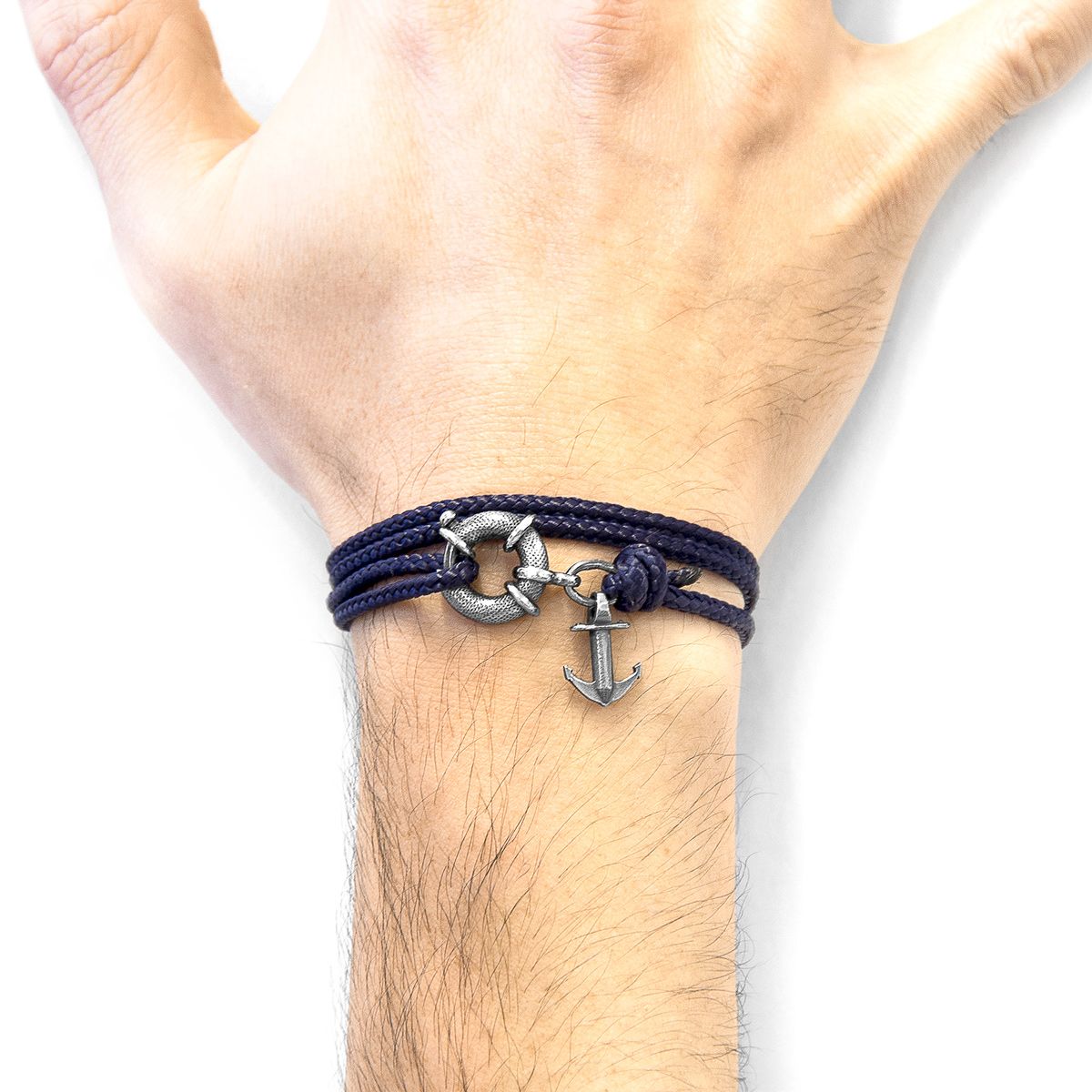 The Navy Blue Clyde Anchor Silver and Rope Bracelet was both designed and skilfully handcrafted completely in Great Britain, In Quality We Trust. For the Modern Journeyman (and woman), ANCHOR & CREW takes ownership of an exploratory lifestyle and enjoys the Happy-Good Life. Combining British craft manufacturing with a discerning modern-minimalist style, this ANCHOR & CREW bracelet features:

3mm diameter performance Marine Grade polyester and nylon rope (GB) 
Secure solid .925 sterling silver lifeboat clasp and drop anchor (GB)  

SIZING
This bracelet is one size fits all, with the rope able to extend or tighten to suit your wrist size. To take the bracelet on or off your wrist, simply slide the one adjustable knot around the rope to make the loop size smaller or larger. Once set, keep the loop size consistent and simply slide the latch within the clasp and feed the rope into or out of the toggle.
