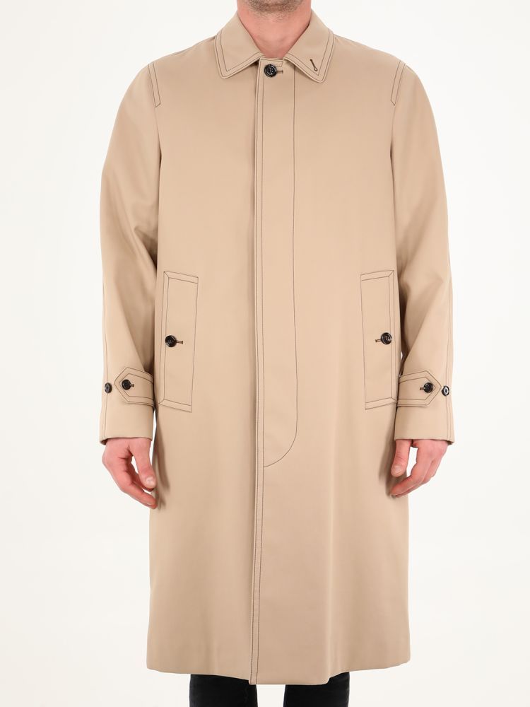 Alderford single-breasted coat in beige cotton with contrasting stitching. It features front closure, classic collar, two side pockets with button, buttoned cuffs, back slit and inner lining with tartan motif. The model is 184cm tall and wears size 48.  