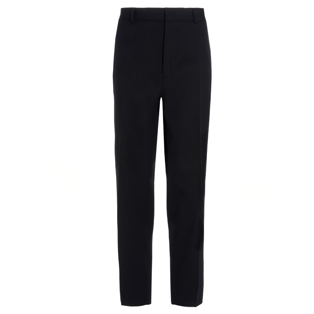 Very dark blue wool trousers with a central pleat, a zip, hook-and-eye and button fastening, welt pockets, a tapered cropped leg, and a relaxed fit.