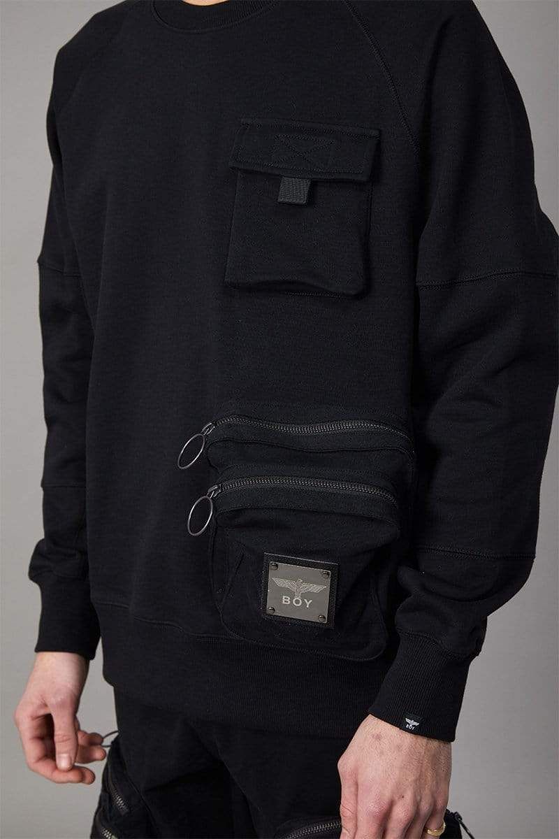Crewneck, long-sleeve sweatshirt with metal BOY Eagle logo badge attached to front and 'leave the BOY alone' script printed on back. Covered chest pocket, 2 utility style zip pockets and ribbed cuffs and hems