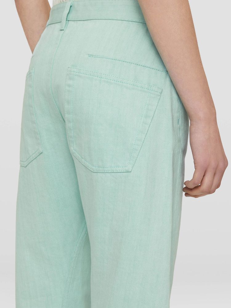Workwear trousers in turquoise cotton with relaxed fit. It features concealed button closure, five-pocket design and fringed hems. The model is 177cm tall and wears size DE 32.