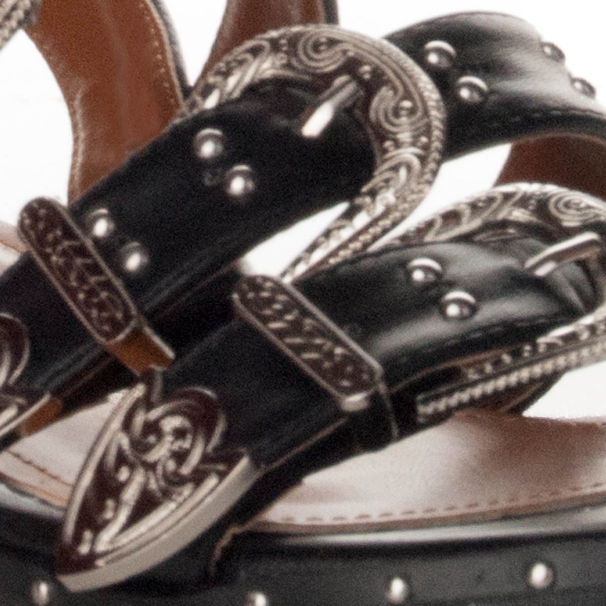 Sandal decorated with brooches and tacks. Fastened in the ankle by metal brooch. It is one of the styles that are more fashionable this summer, for its rocker style. Very comfortable and current.