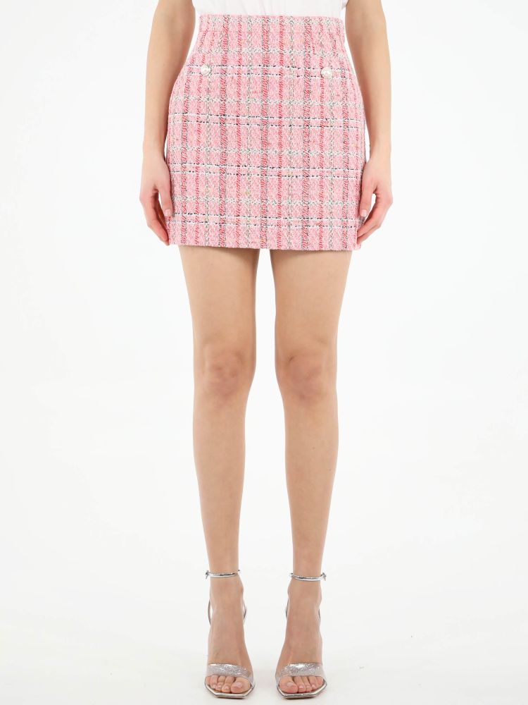 Pink checked tweed miniskirt. It features two mother-of-pearl buttons on the front and side zip closure with hook-and-eye. The model is 178cm tall and wears size 40.