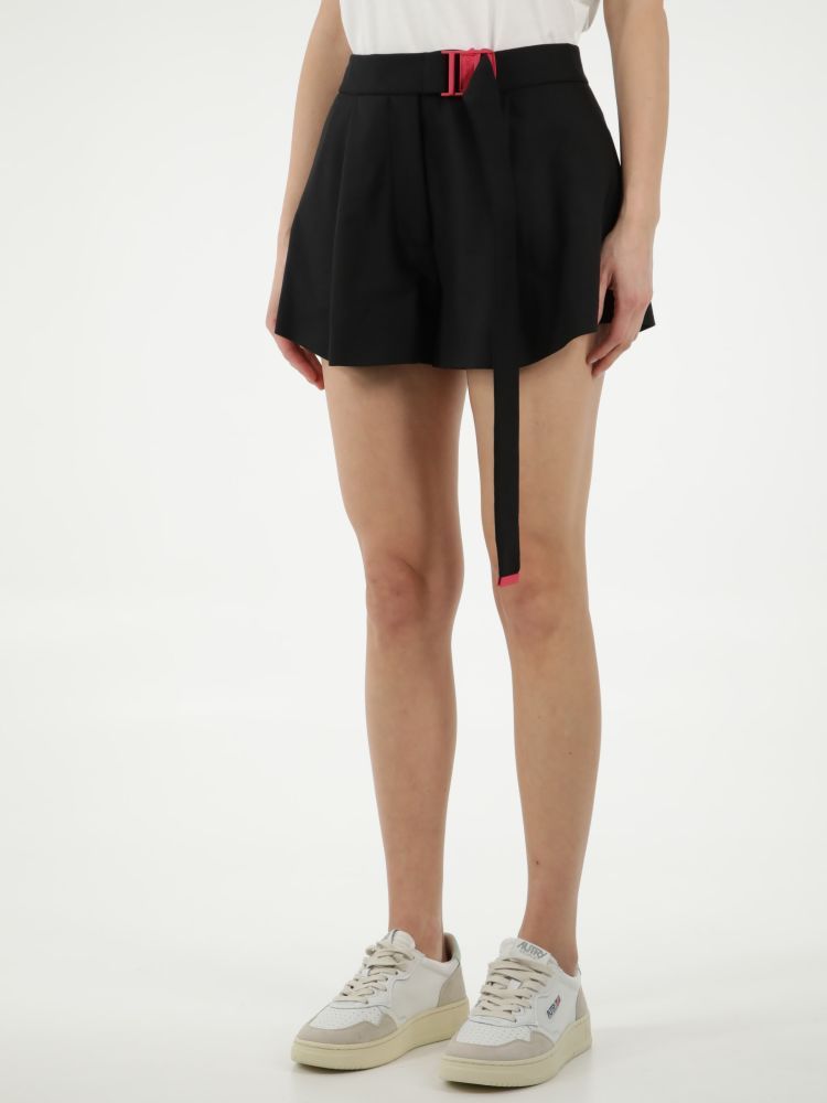 Black shorts characterized by a waist belt with an adjustable red logoed buckle. It features front pleats, two side welt pockets and two rear welt pockets. The model is 178cm tall and wears size 28.