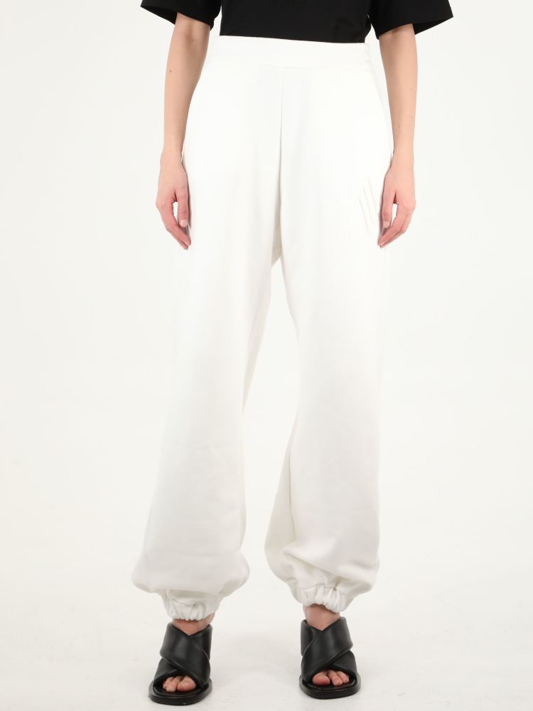 White joggers with The Attico embossed logo on the front, elasticated waist and ankles. The model is 180cm tall and wears size 38.  
