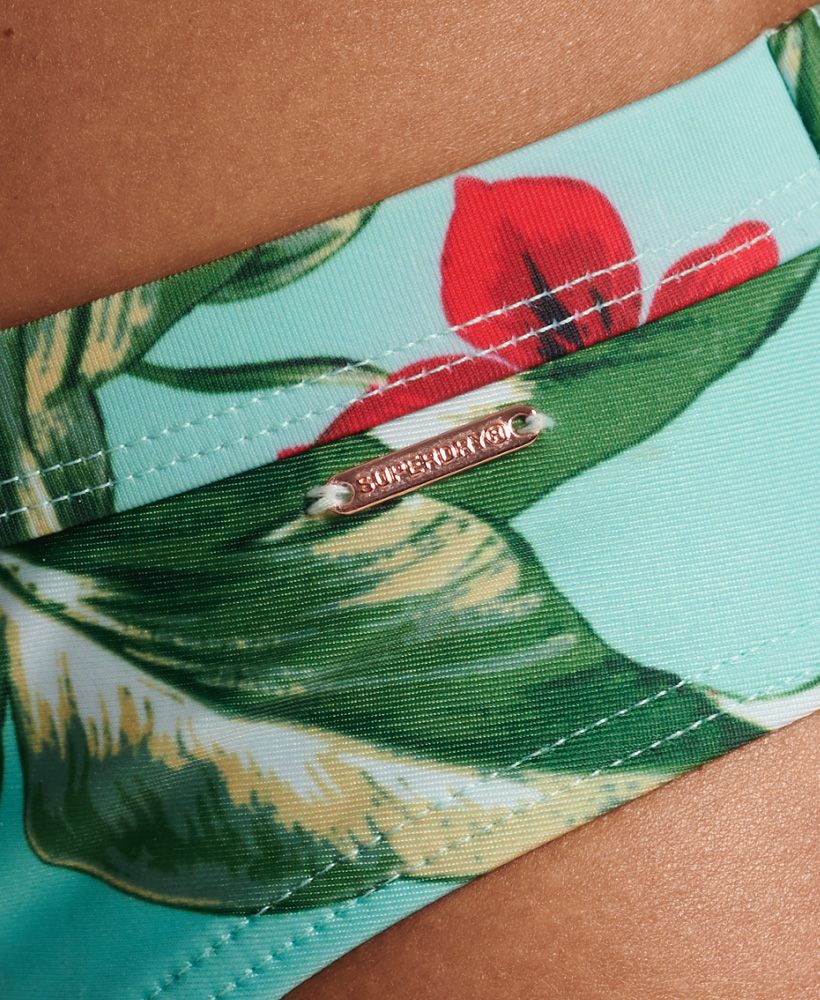 Hawaiian print is an iconic part of the classic vintage vibe, and we love how it evokes a retro style. Whether you're travelling far or staying at your local spots this sunny season, you can bring the holiday spirit with you anywhere you go. These briefs have a bold chic, whether worn by themselves or beneath a day dress on those lovely long days.Hipster brief styleAll over printElasticated waistMetal Superdry tabRecycled contentsPlease note, due to hygiene reasons we are unable to offer an exchange or refund on swimwear unless the hygiene strip is still intact. This does not affect your statutory rights.By 2050, there will be more plastic in the ocean than fish.Help save plastic from polluting the earth. Wear this instead.This new swimwear fabric is made from 80% recycled post-consumer waste.Indo green leaves and red flowers against a delicate mint
