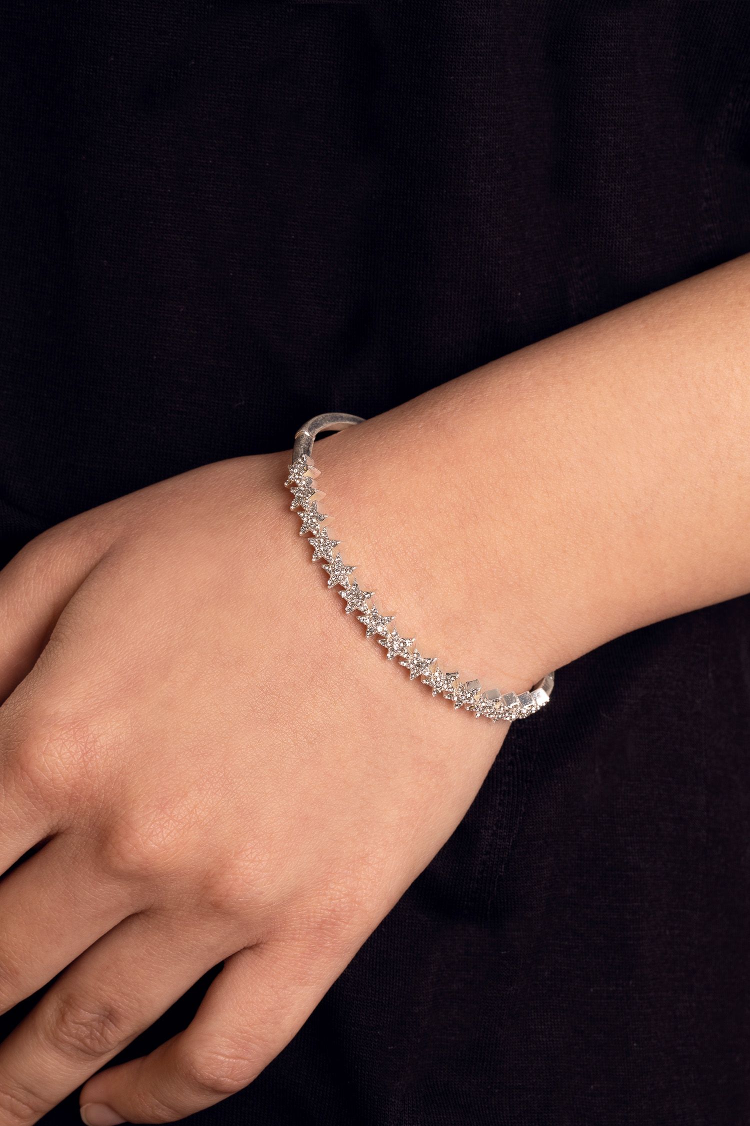 The Kate Thornton Silver Plated Delicate Star Sparkly Bracelet adorned with pave crystals is a show stopping piece to add a touch of glamour to your look day through to night. The delicate star has a hinge fastening that makes it easy and comfortable to wear, no matter where you're headed so make your everyday outfit more special with a little bit of sparkle from this pretty bracelet. The silver tone bracelet dimensions are 6cm x 5cm and features a hinge fastening which you simply press in lightly and open up.  Presented in a KTx jewellery pouch to keep your jewellery safe or ideal for gifting!