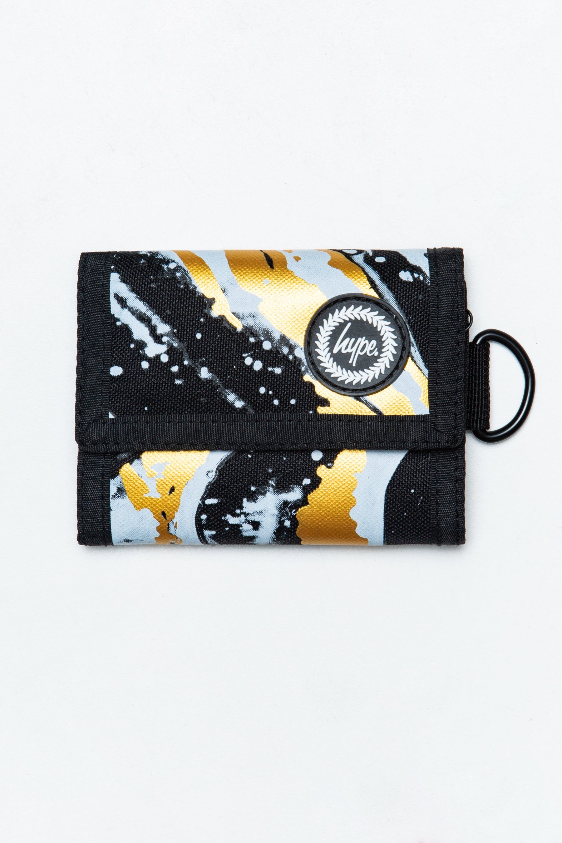 let us introduce you to the HYPE. Liquid Gold Wallet. A unisex wallet shape and design, creating the perfect lightweight wallet you need as your money and card holder. Featuring a marble inspired liquid effect in a monochrome and gold colour palette. Finished with Velcro fastening and the iconic HYPE. crest logo in a raised rubber fabric. Wipe clean only.