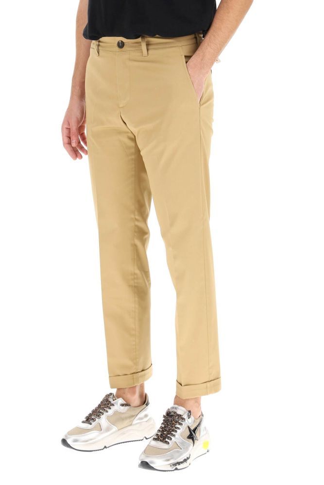 Golden Goose trousers in cotton gabardine, slightly stretch, featuring a chino cut with cuffed straight leg. Regular waist, zip and button closure, side slash pockets, coin pocket, bound rear pockets with button. Micro metal Star applications on the back, removable embroidered G label on the front. The model is 185 cm tall and wears a size IT 46.