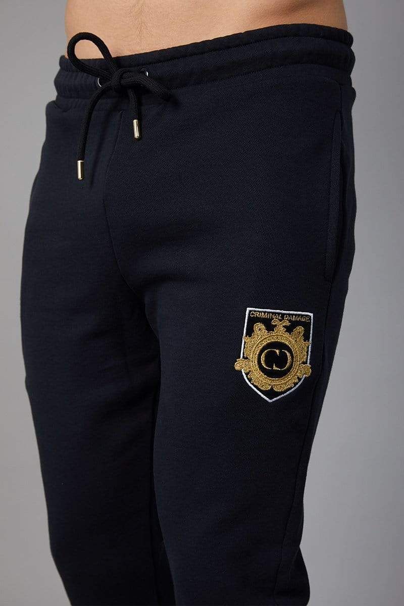 Black joggers with embroidered gold/white CD crest on left leg, with black drawstring waistband, Slim fit, 2 front pockets and 1 back pocket, Black drawstring