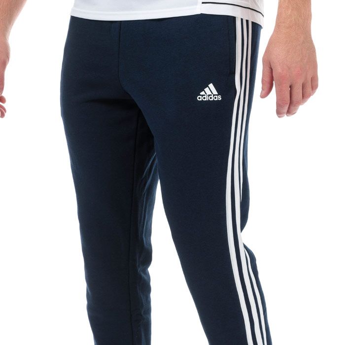 Mens adidas Essentials 3-Stripes French Terry Pants in collegiate navy - white.<BR><BR>- Elasticated waist with inner drawcord.<BR>- Applied 3-Stripes to sides.<BR>- Front welt pockets.<BR>- Open hems.<BR>- adidas Badge of Sport logo printed at left hip.<BR>- Tapered leg.<BR>- Slim fit.<BR>- 70% Cotton  30% Recycled polyester.  Machine washable.<BR>- Ref: CW3883