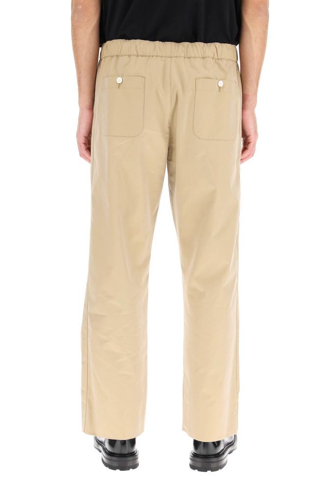 Alexander McQueen informal trousers cut from lightweight cotton gabardine to a loose fit. It features an elasticated waistband, piped side pockets, rear patch pockets with button, zip fly. The model is 186 cm tall and wears a size IT 48.