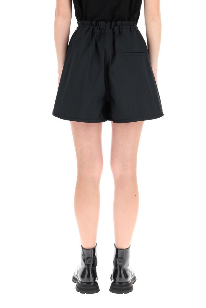 Alexander McQueen loose shorts in polyester faille with rounded side vents at the hem. Elasticated waist with drawstring and steel-finish metal lock, side inseam pockets, rear welt pockets. The model is 177 cm tall and wears a size IT 40.